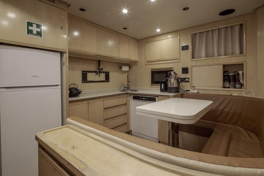 Luxurious yacht kitchen interior with modern appliances, beige cabinetry, and cozy seating, CRN 129, 2009.
