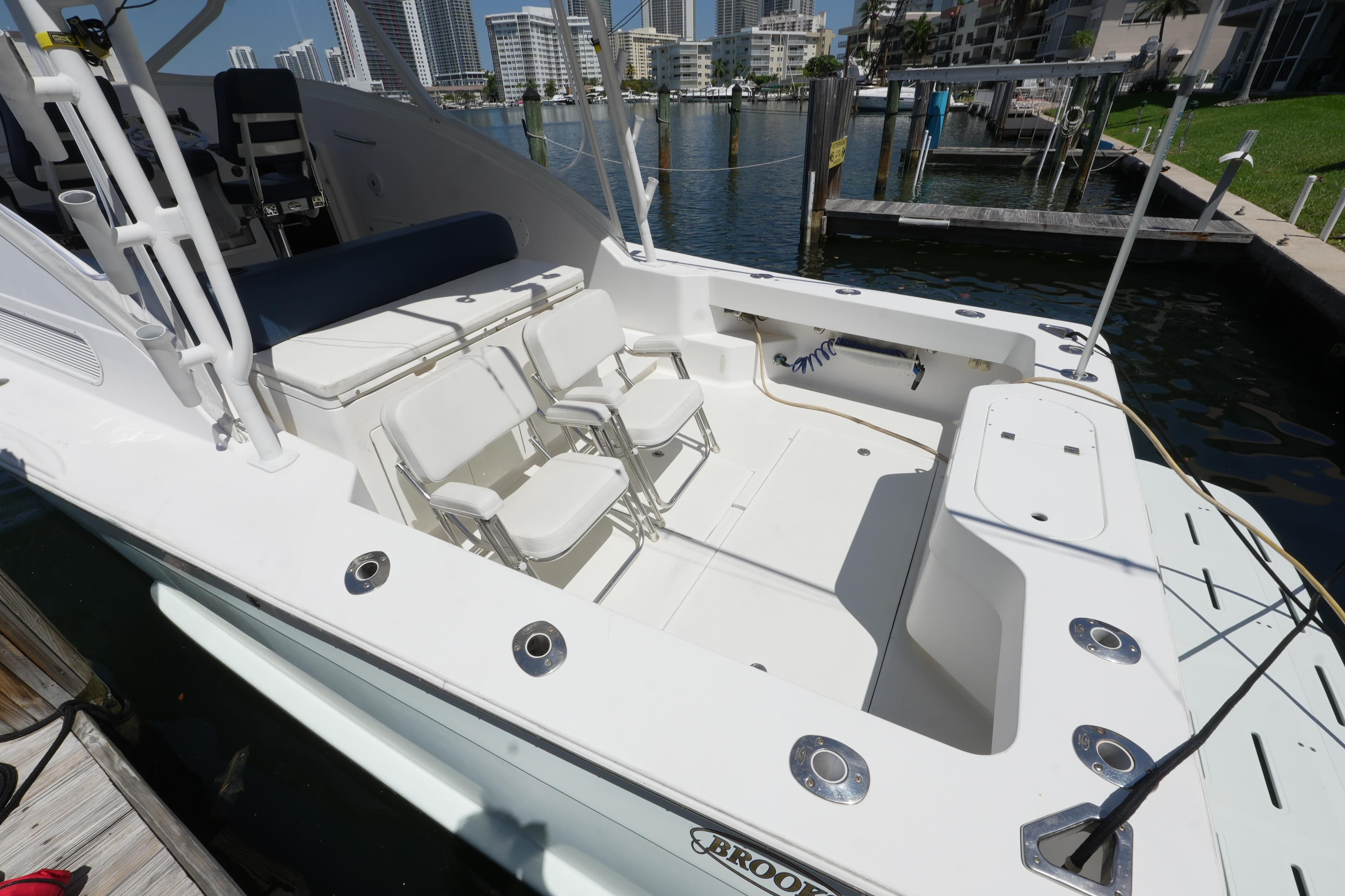 Custom Carolina 34 boat, 2012 model, featuring spacious deck with seating, docked in marina.