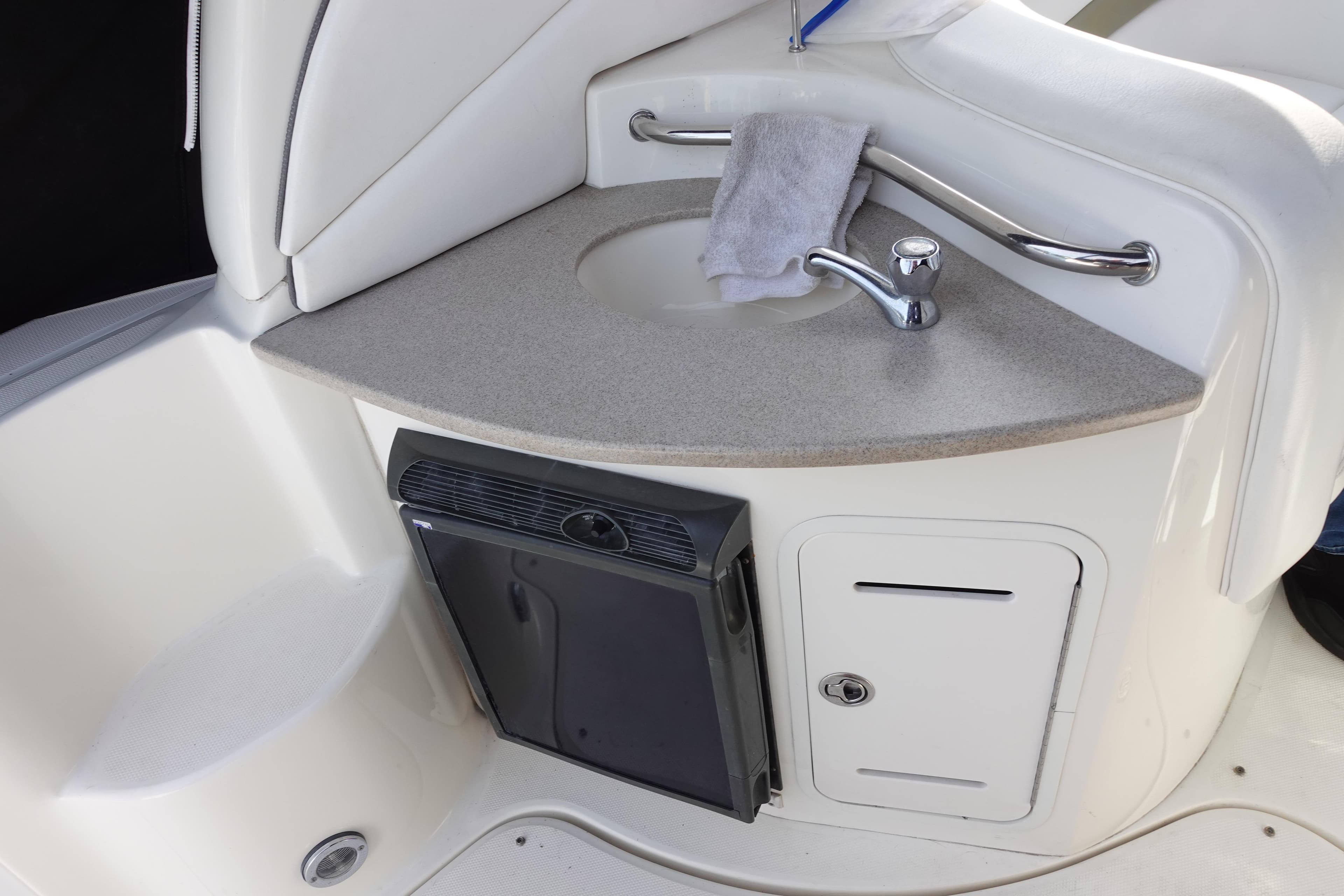 2007 Sea Ray 320 Sundancer boat interior with sink and mini fridge.