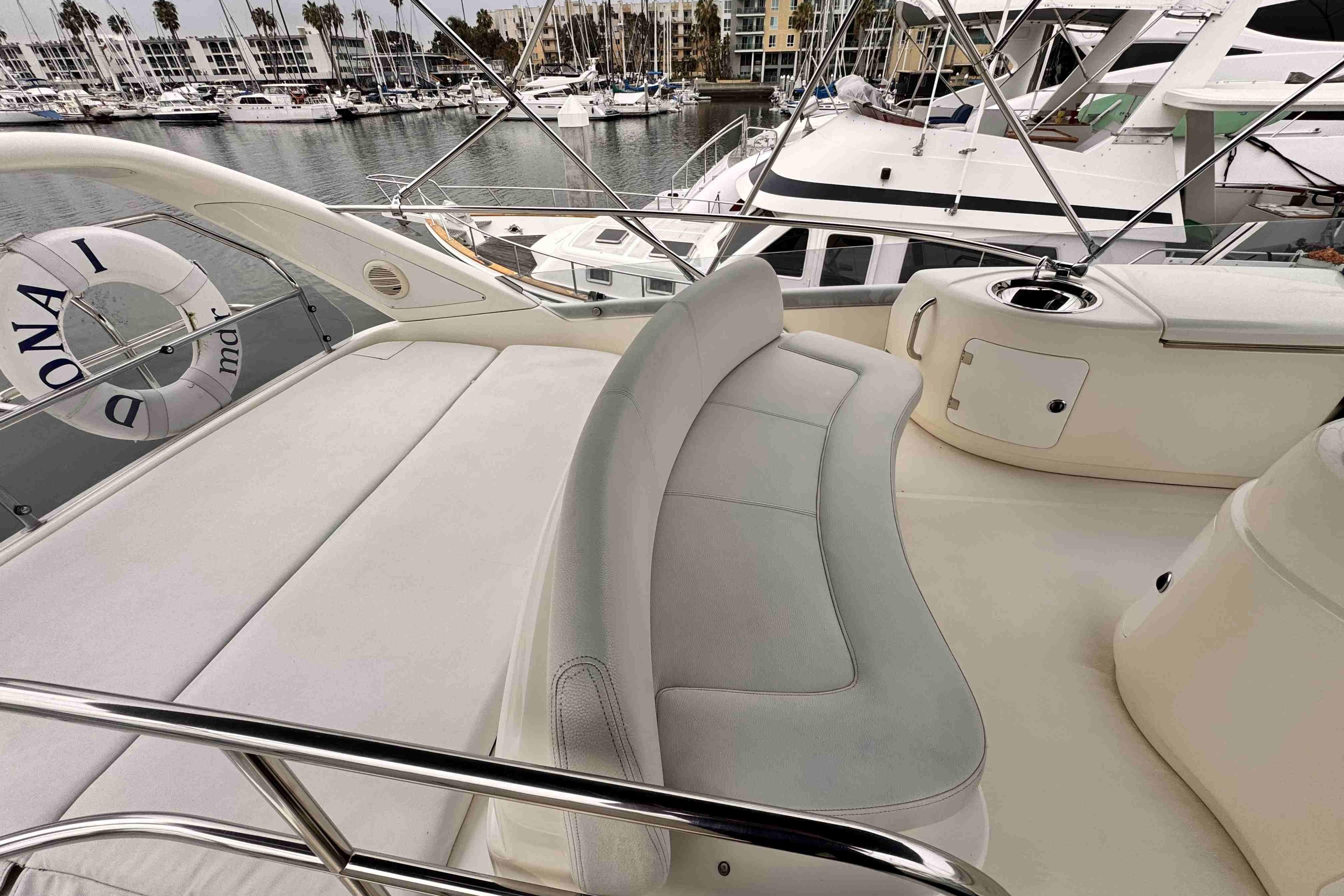 Luxurious Cranchi yacht deck with seating, docked at marina with other boats.