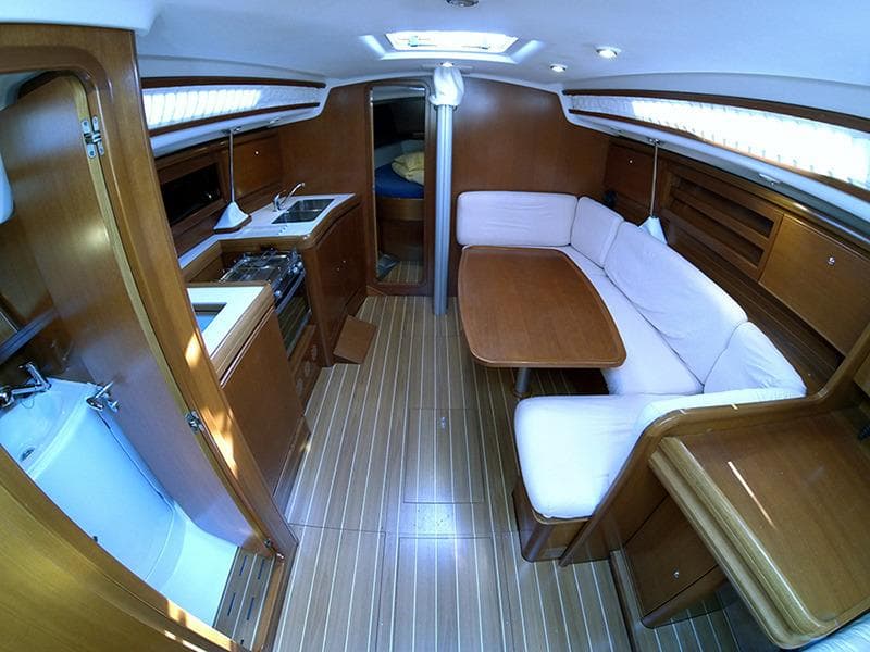 Interior of a 2010 Grand Soleil 37 yacht with wooden finish and cozy seating area.