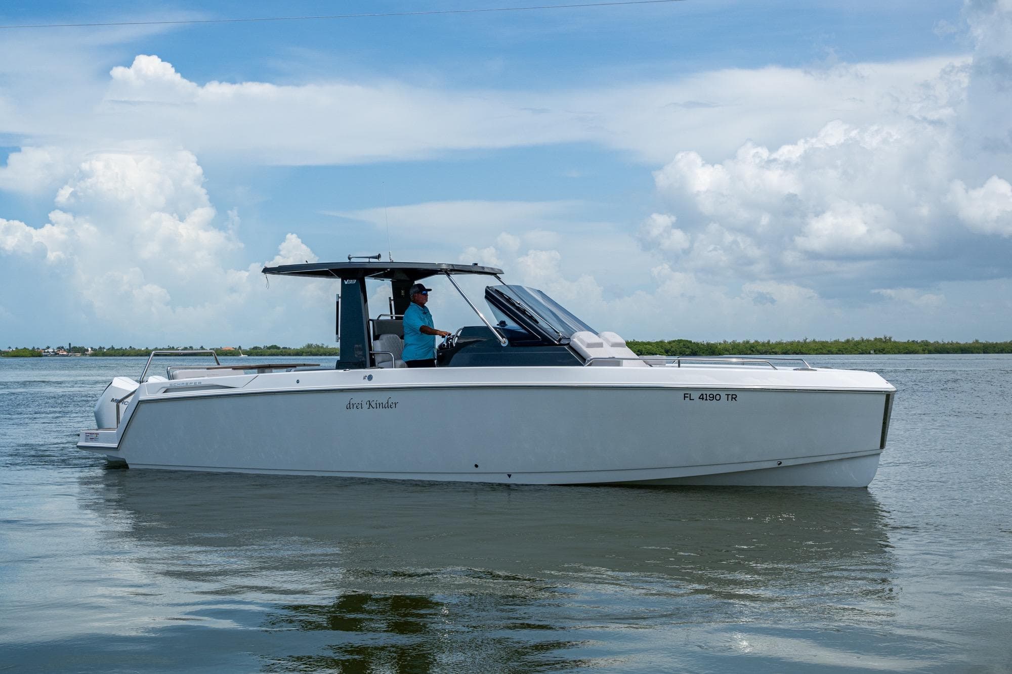 2023 Schaefer V33 boat cruising on calm waters under a partly cloudy sky.