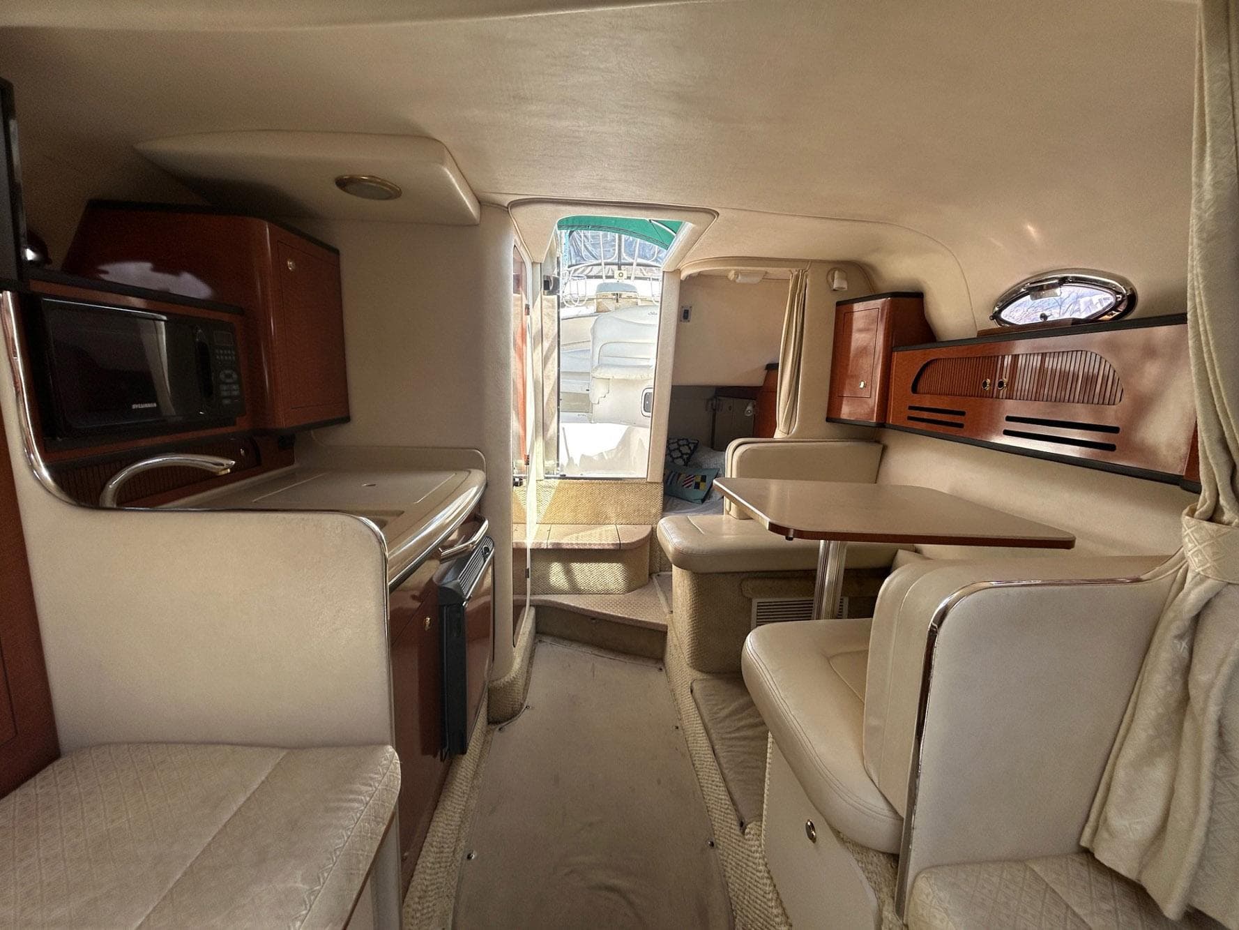2004 Sea Ray 280 Sundancer cabin interior with kitchenette and seating area.