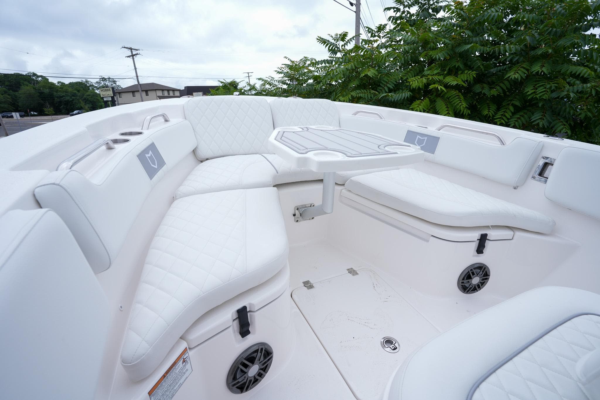 Luxurious seating area on 2026 Sea Fox 228 Commander boat, featuring white cushioned seats and table.