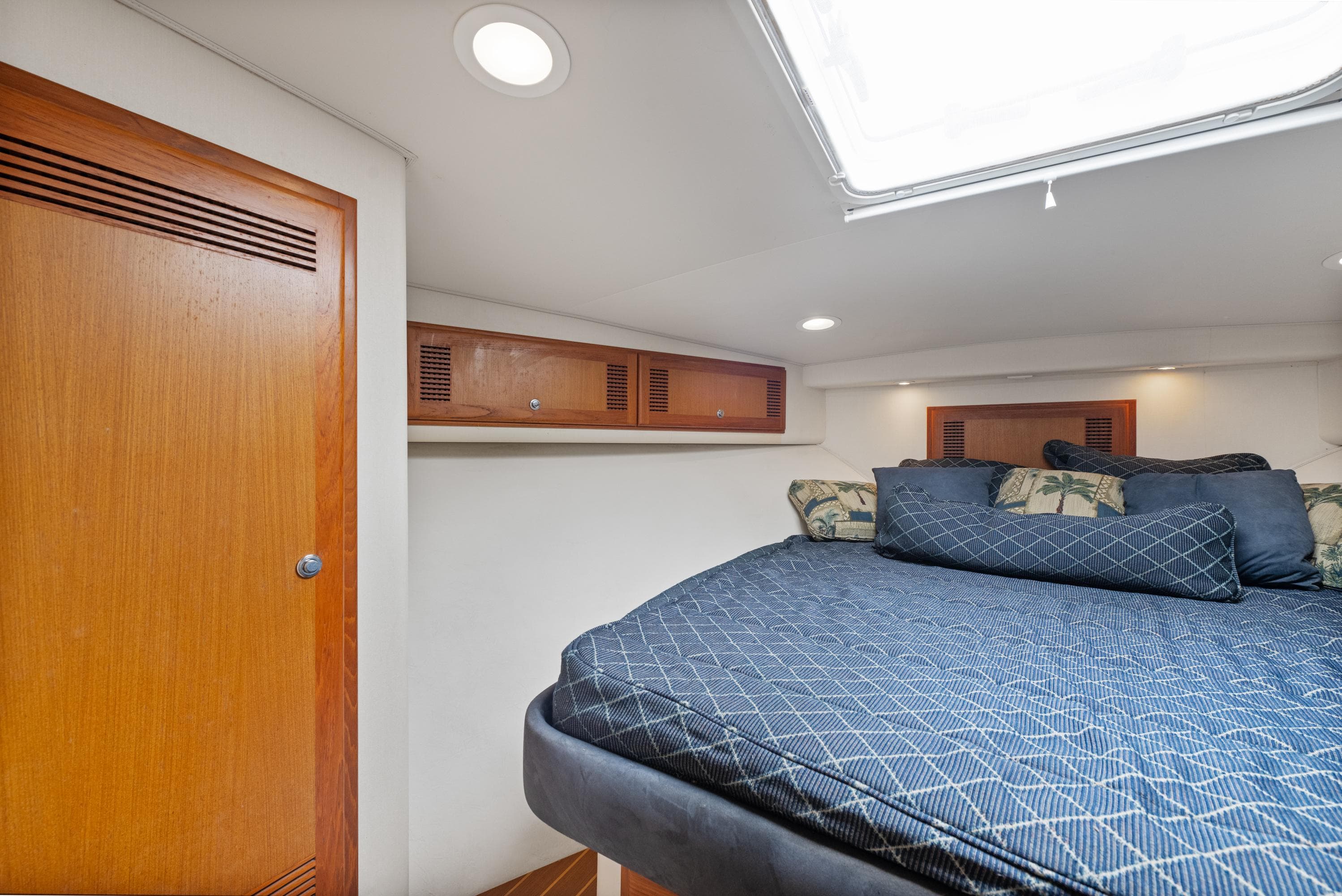 Interior cabin of 2004 Cabo 40 Express yacht with bed and wooden storage.