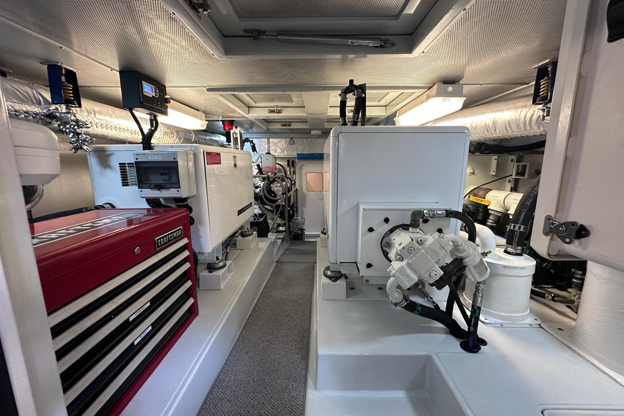 Engine room of a 2016 Nordhavn 60 yacht, featuring equipment and tool storage.