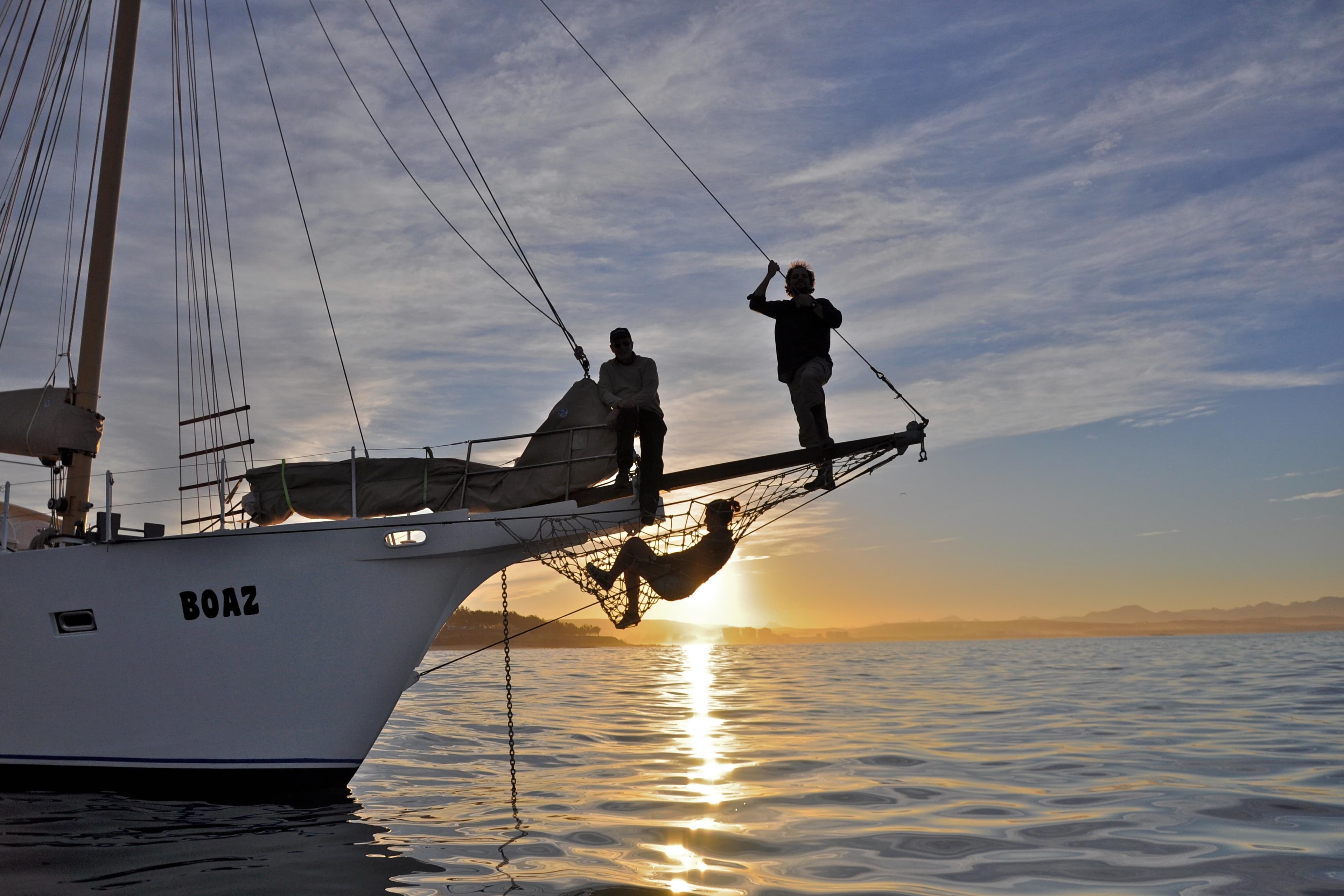 Sailing at sunset on a 2015 Boden Schooner, with people enjoying the view.