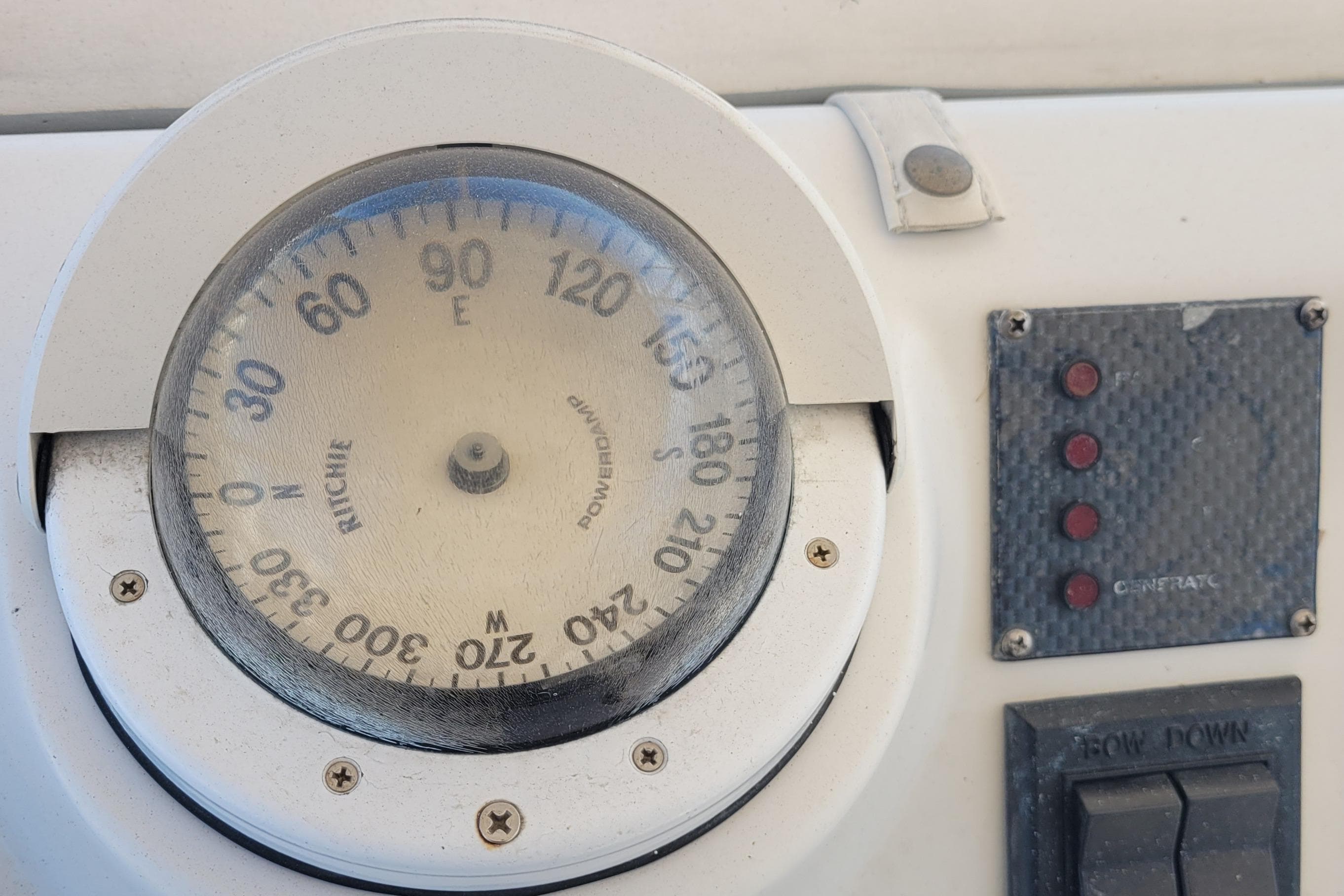Compass and control panel on a 2001 Luhrs 34 Convertible boat.