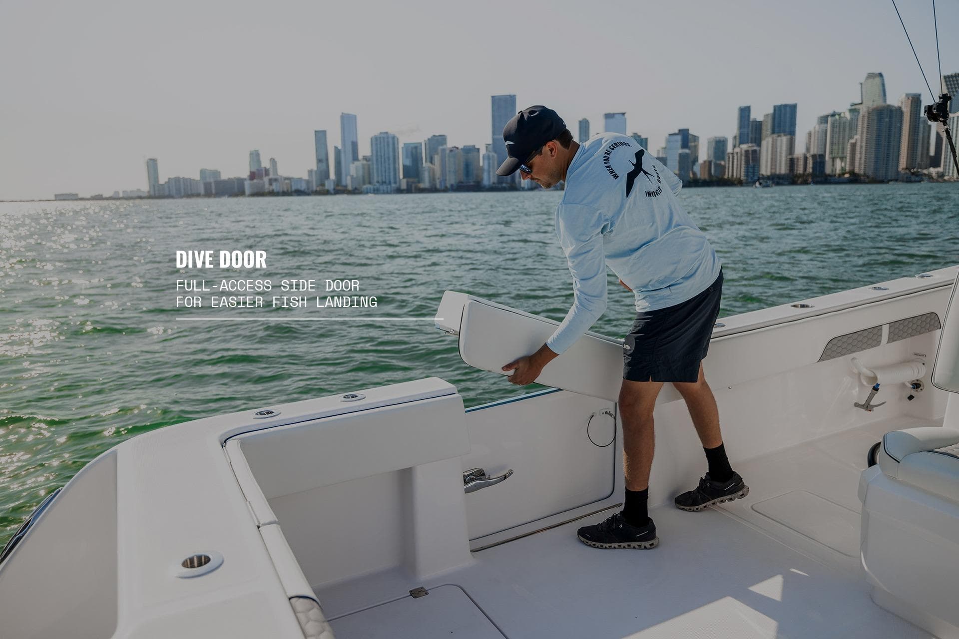 2026 Invincible 36 Catamaran with full-access dive door, ideal for fishing near city skyline.