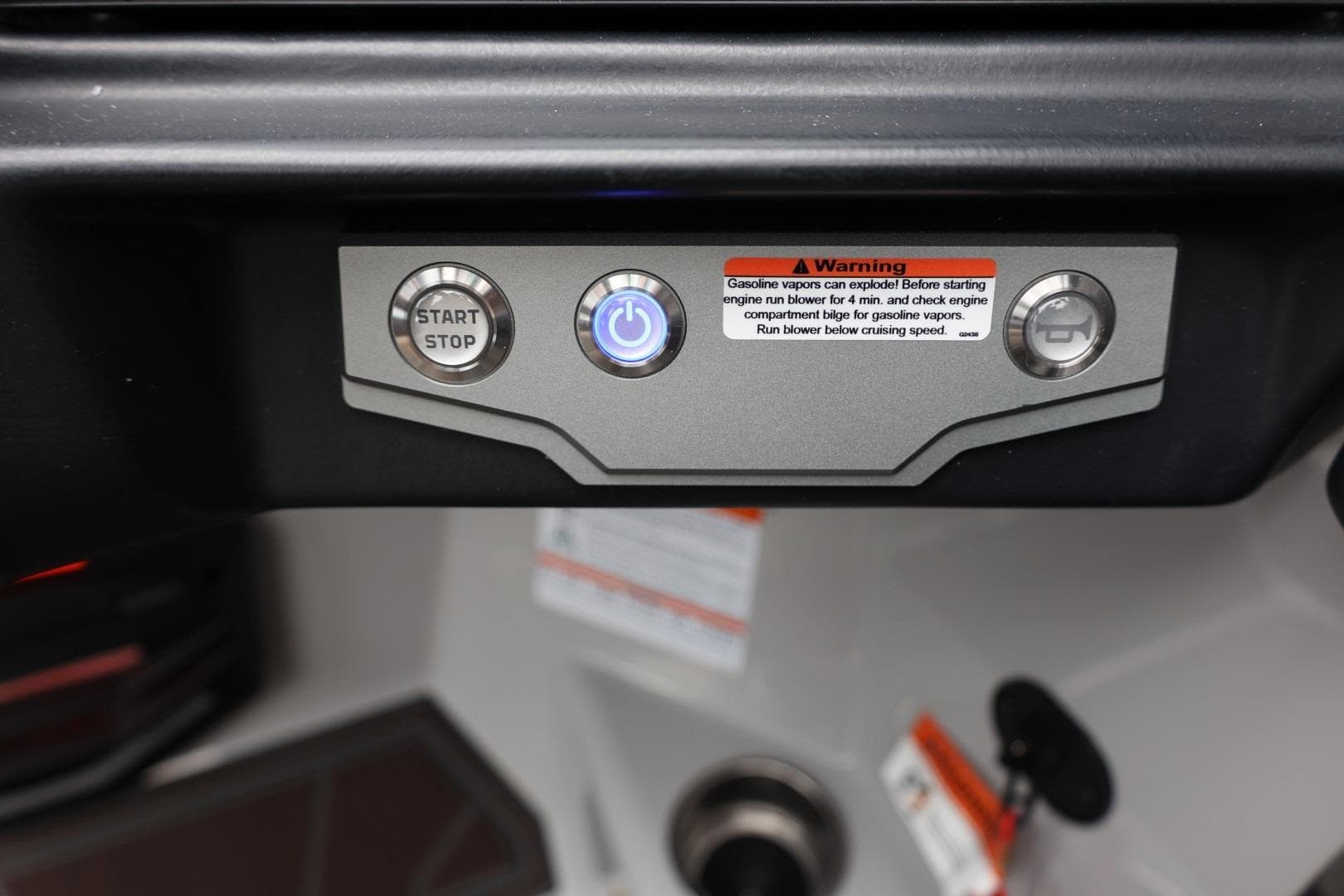 Control panel of 2026 Tigé 22RZX boat with start/stop button and warning label.