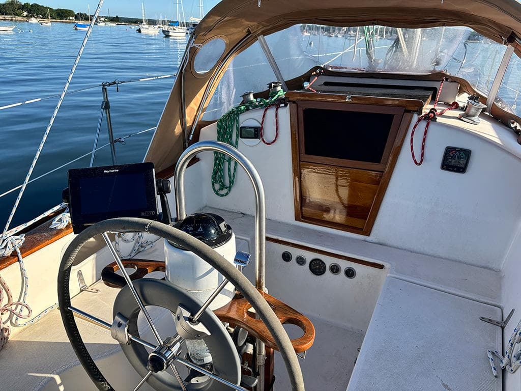 Cockpit of 1981 Sabre 30 sailboat with steering wheel and navigation equipment.