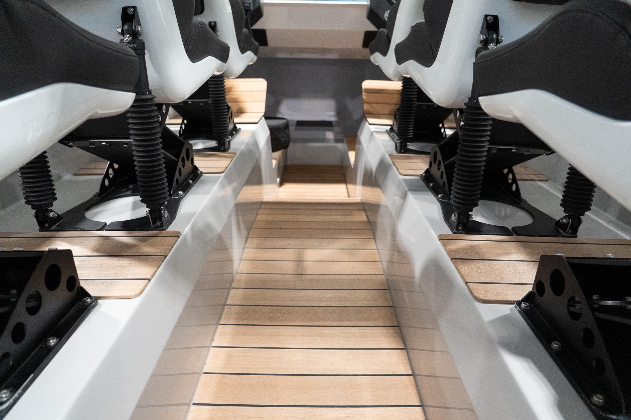 Interior view of 2025 Goldfish X12 Explorer boat with cushioned seats and wooden flooring.