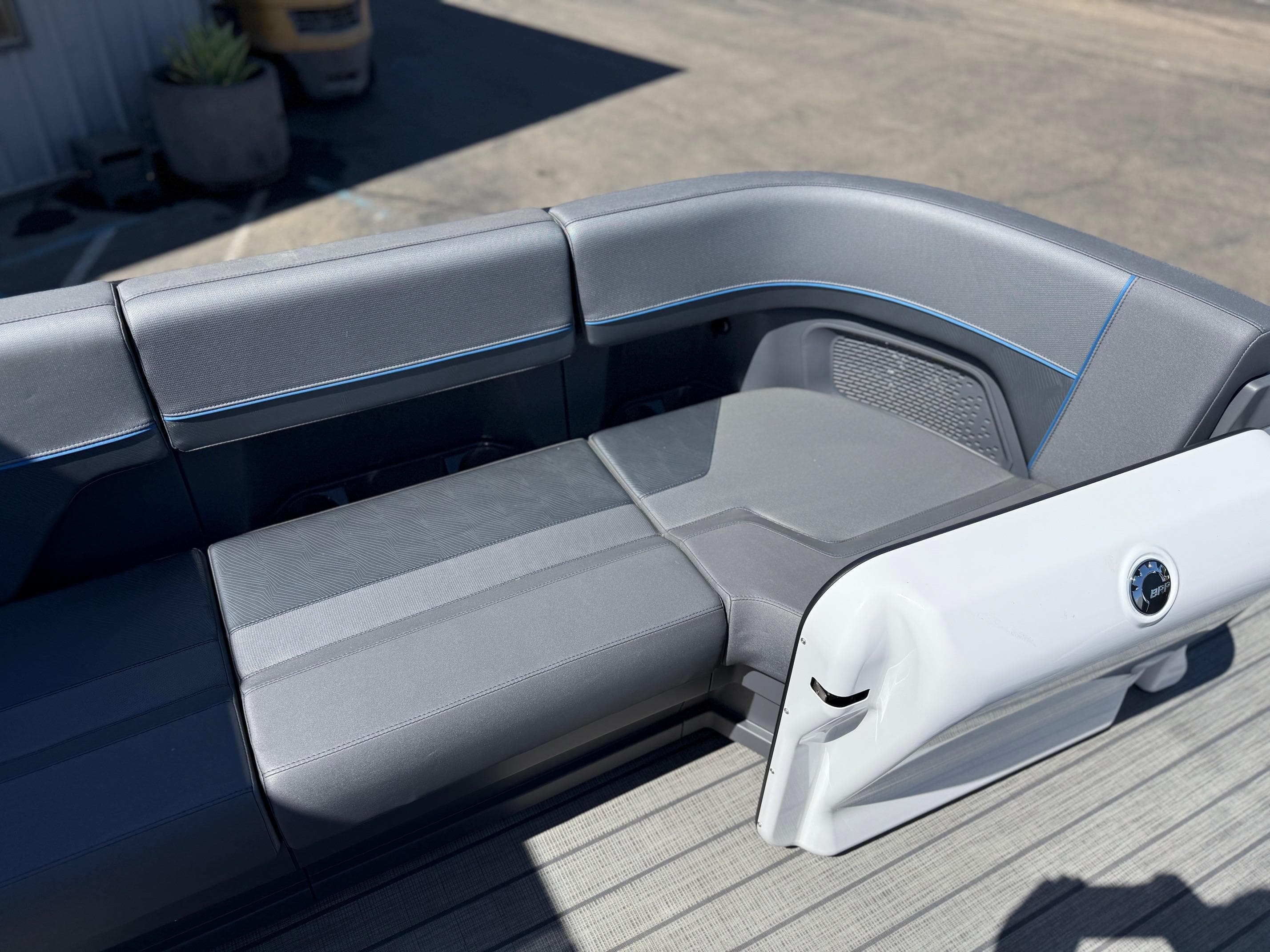 2025 Manitou Explore Dual Engine boat interior with sleek gray seating and modern design.