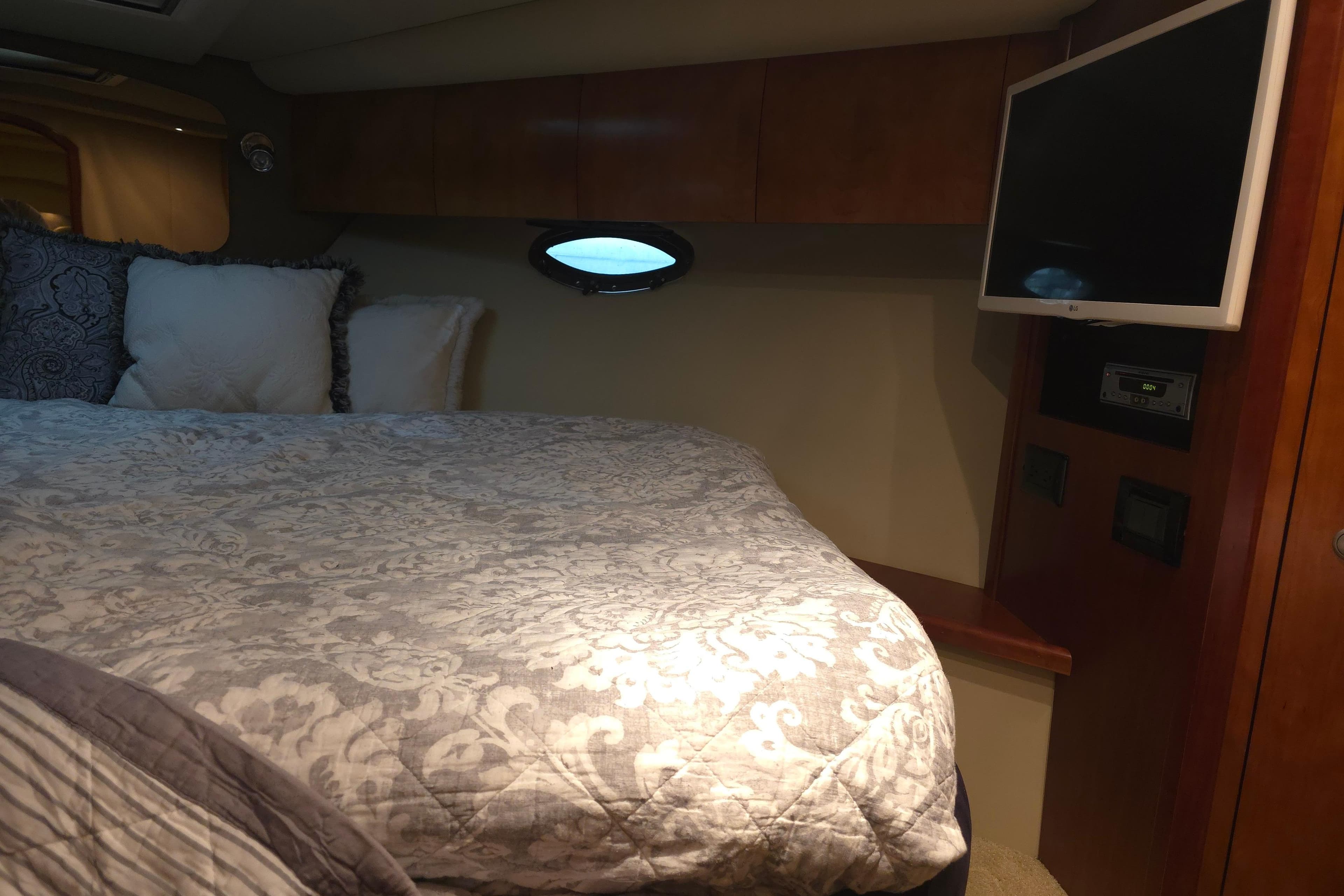 Luxurious cabin interior of 2008 Cruisers Yachts 390 Sports Coupe with bed and TV.