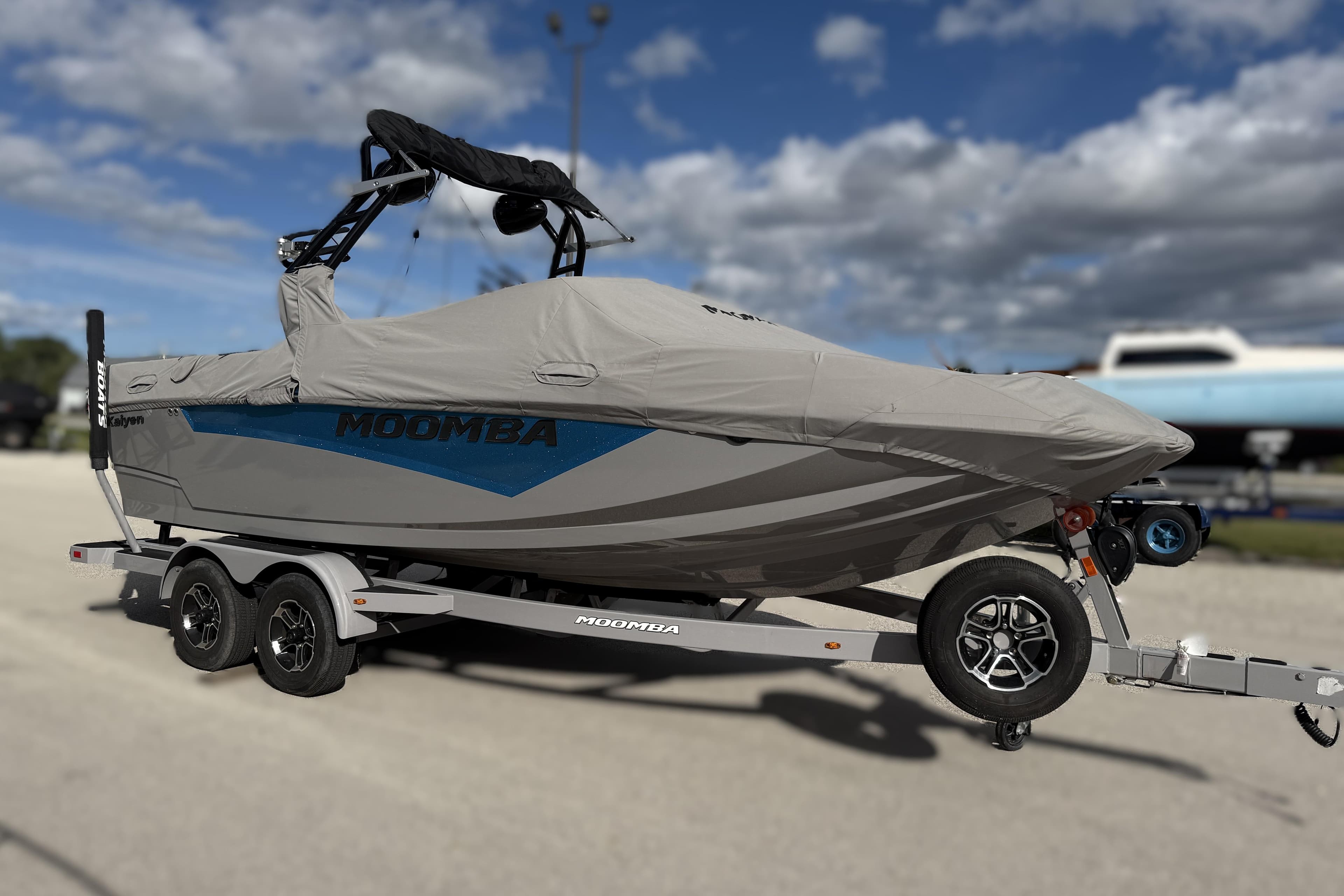 2022 Moomba Kaiyen boat covered on trailer under cloudy sky.