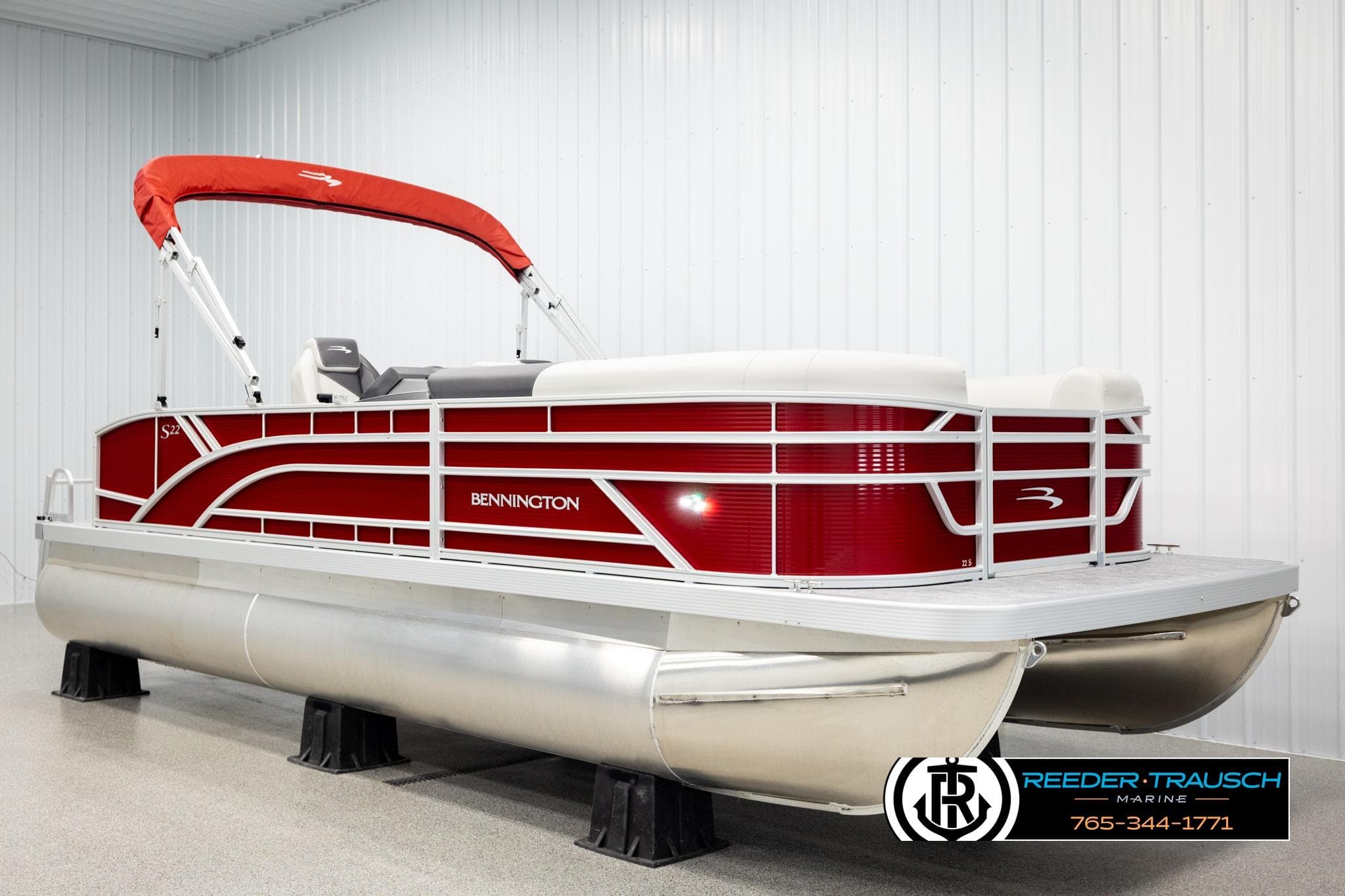 2026 Bennington SSBSF pontoon boat with red and white design in showroom.