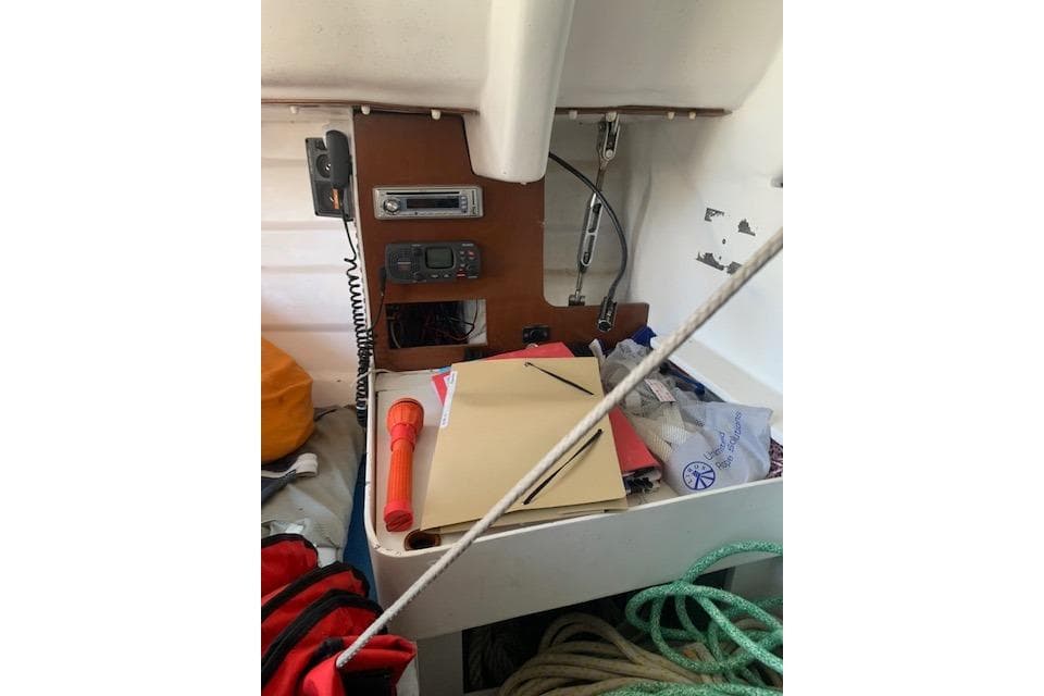 Interior of a 1980 Beneteau Half Tonner sailboat with navigation equipment and supplies.