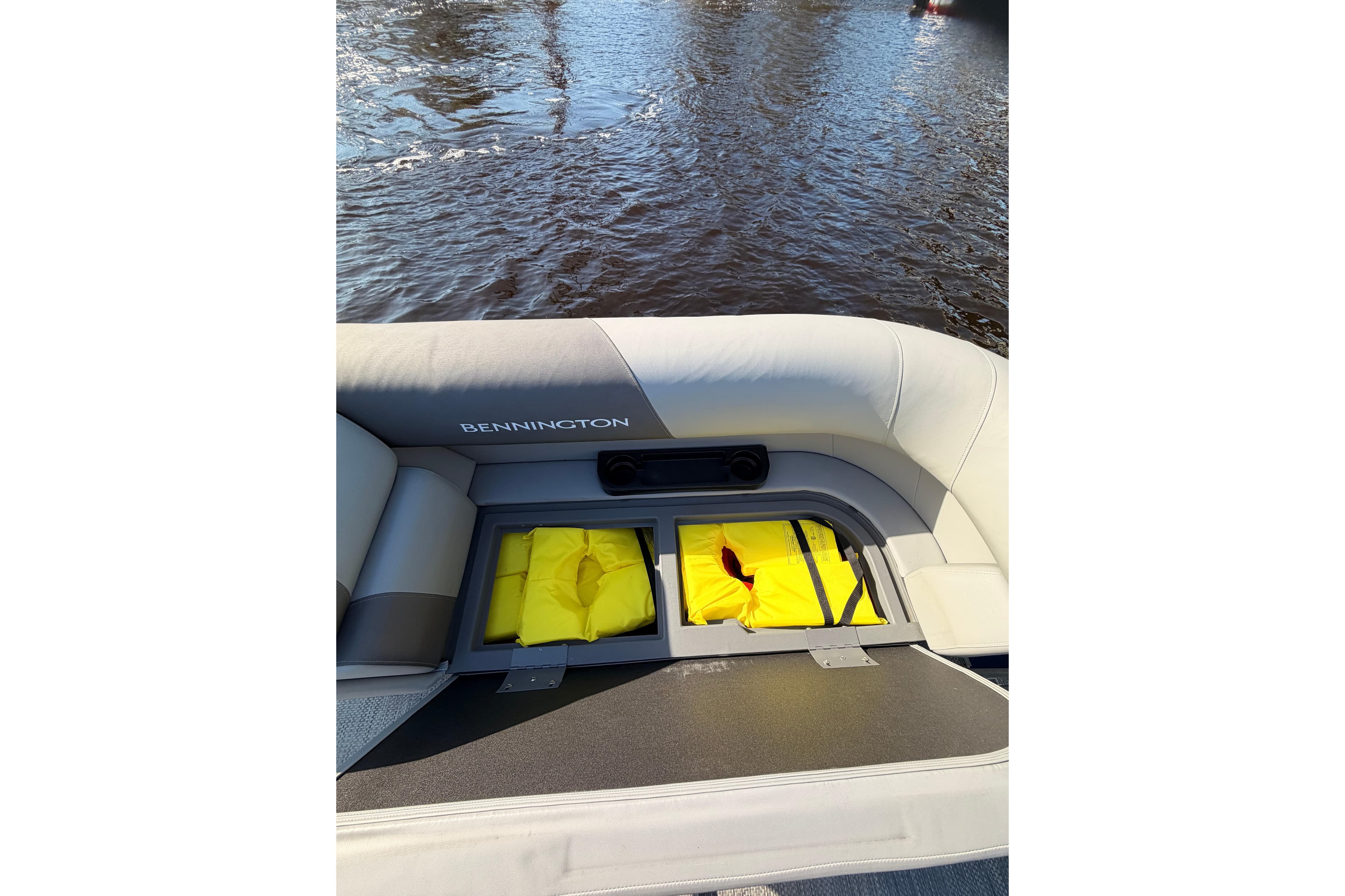 2024 Bennington SVL boat interior with storage compartment and yellow life jackets.