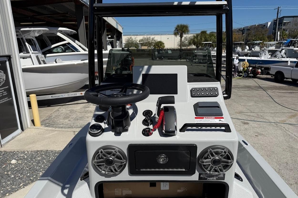 2026 SCB R24 boat console with steering wheel, controls, and speakers in a marina setting.
