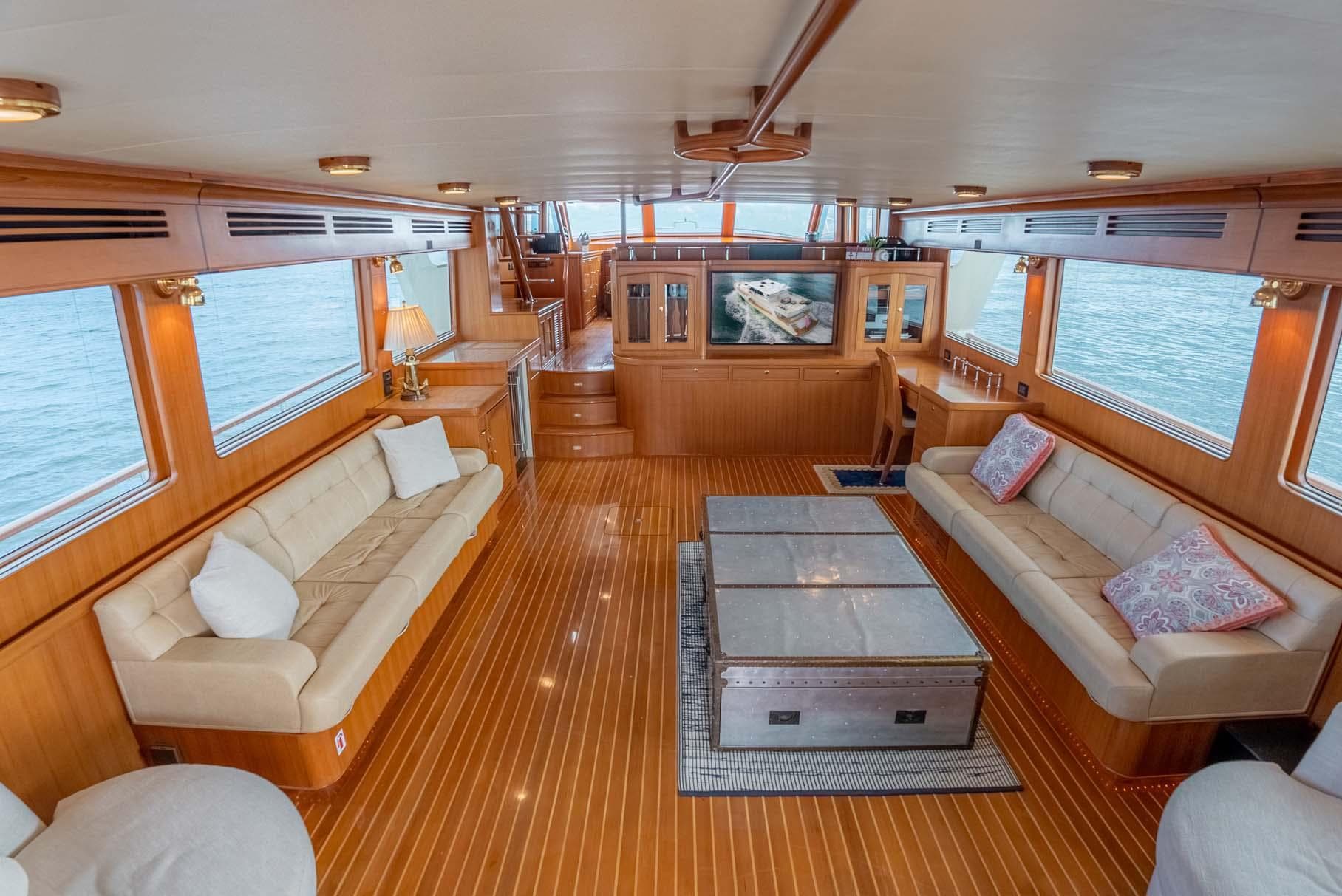 Luxurious interior of 2006 Marlow 72E LRC yacht with elegant wood flooring and plush seating.