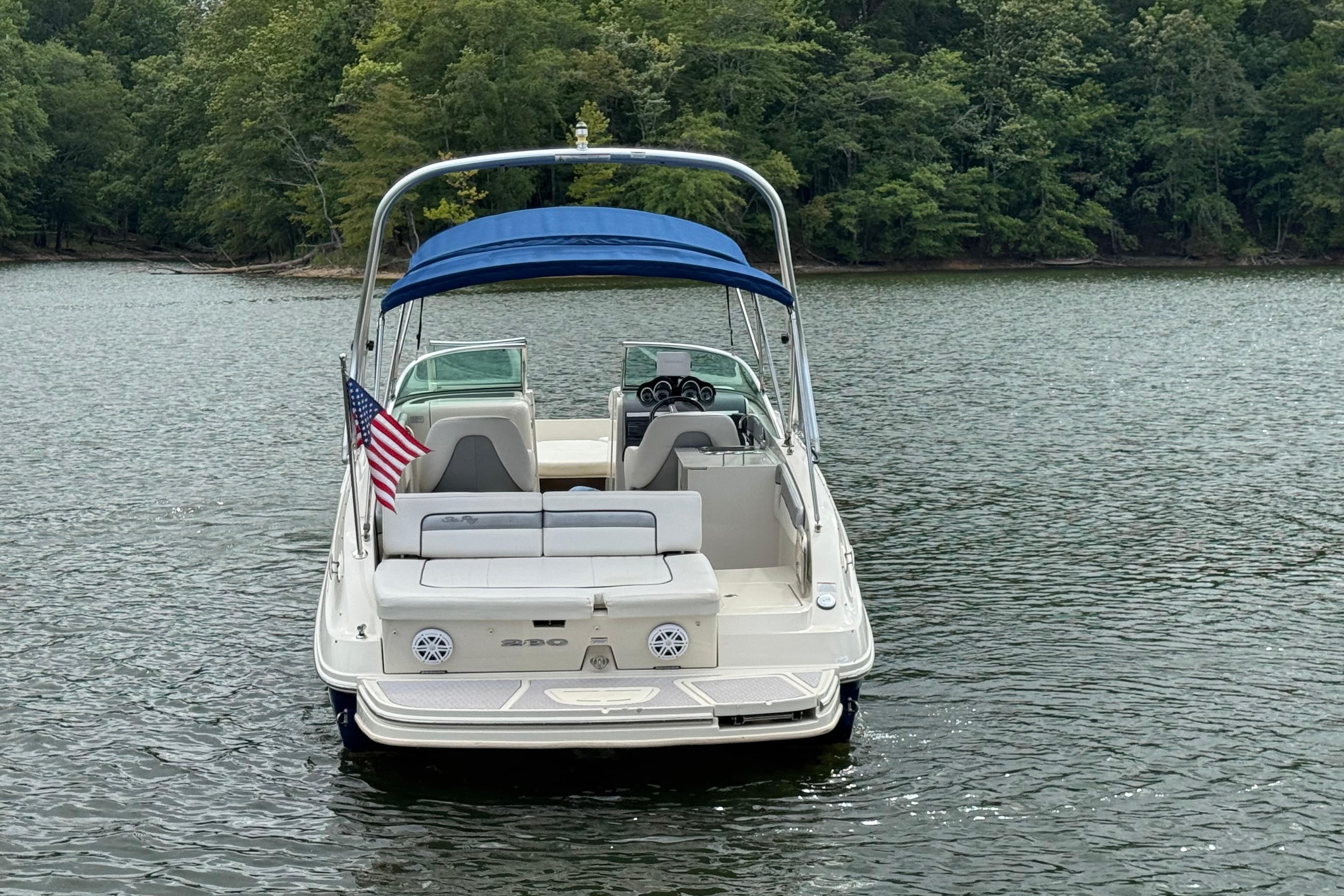 2009 Sea Ray 280 Sundeck boat with blue canopy on a calm lake.
