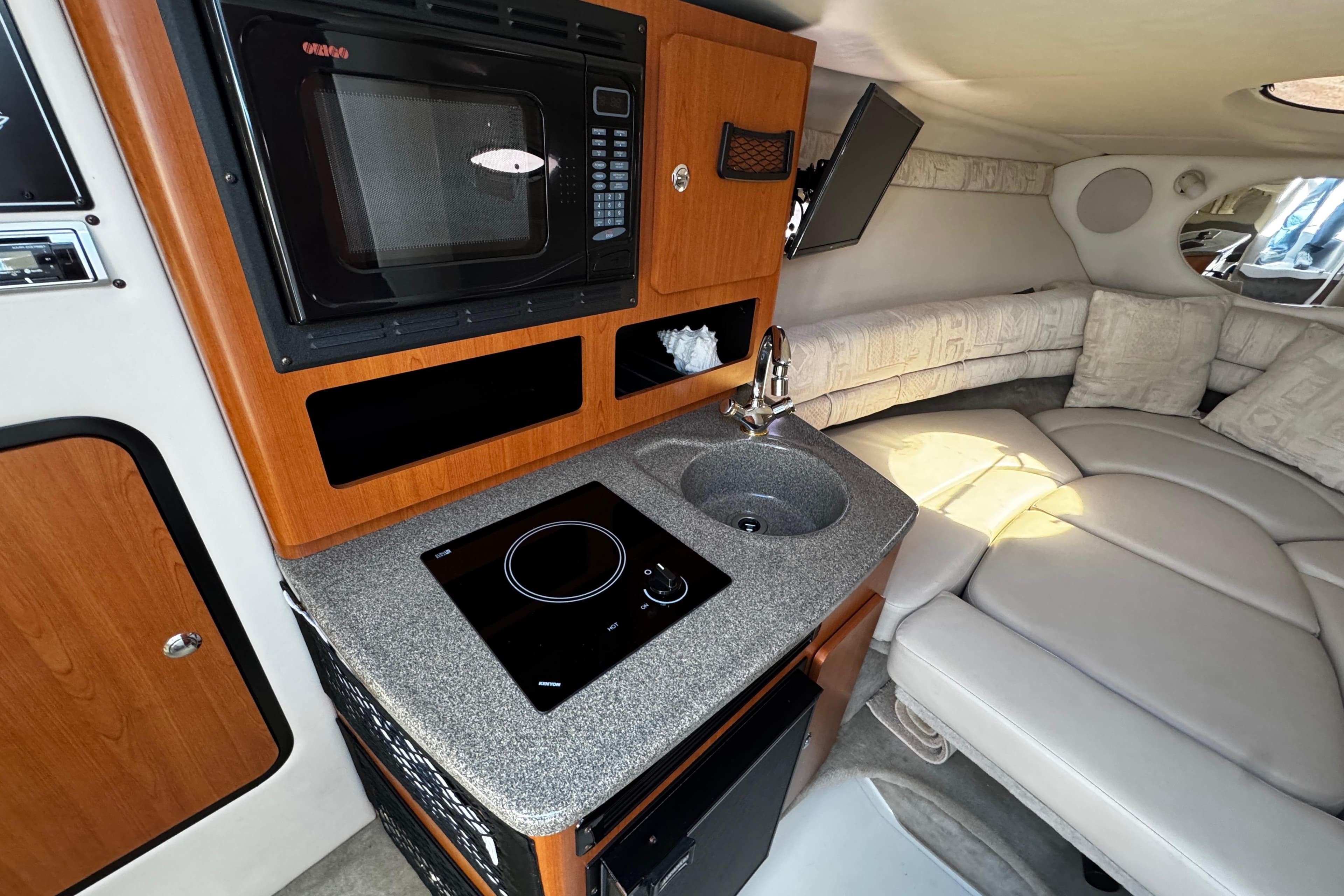 2004 Crownline 250 CR cabin interior with kitchenette, microwave, and seating area.