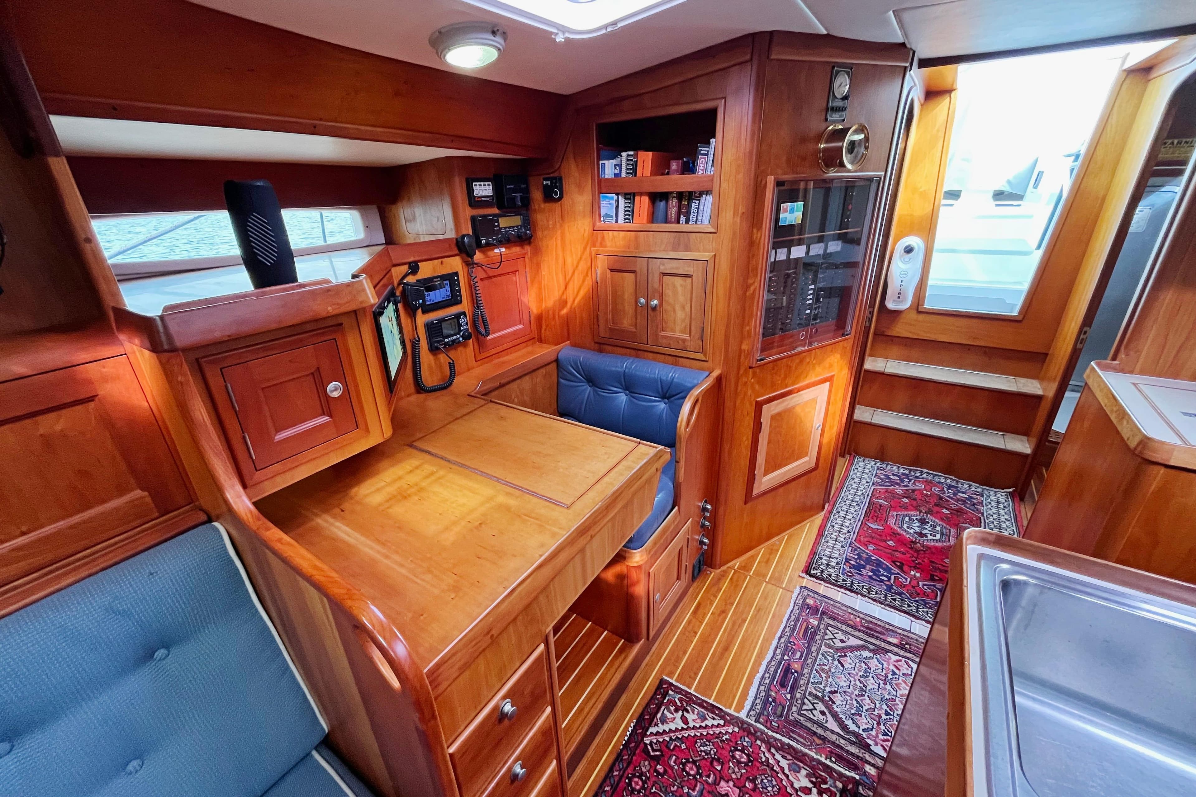 Interior of 1995 Able Apogee 50 yacht with wooden cabinetry and navigation equipment.
