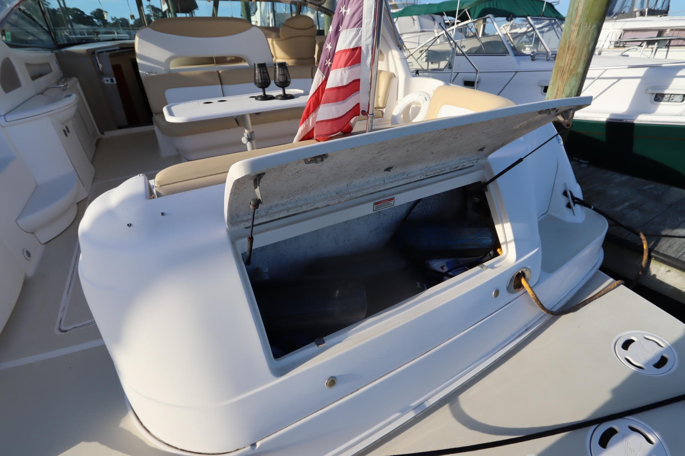 2000 Sea Ray 460 Sundancer yacht with open storage compartment and American flag.