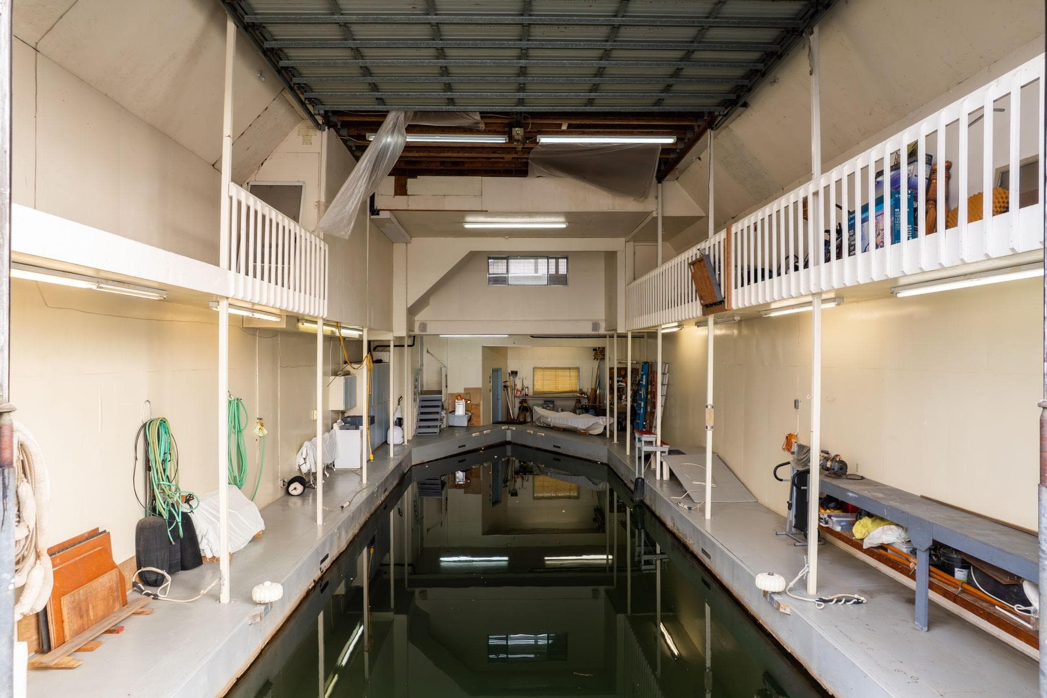 Interior of a 1976 custom boathouse with water channel and storage areas.