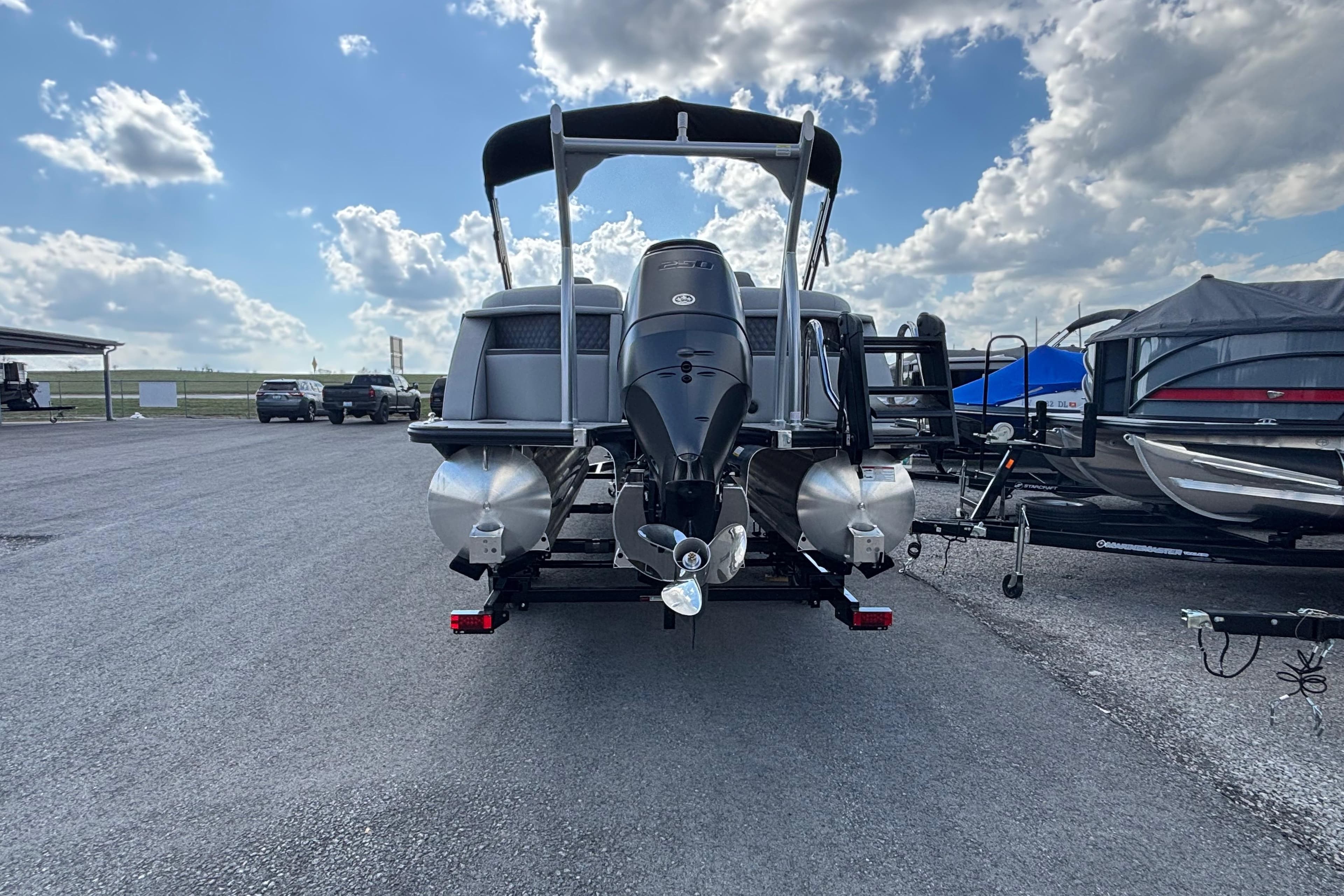 2026 Berkshire 23RFX STS pontoon boat with outboard motor, parked under a cloudy sky.