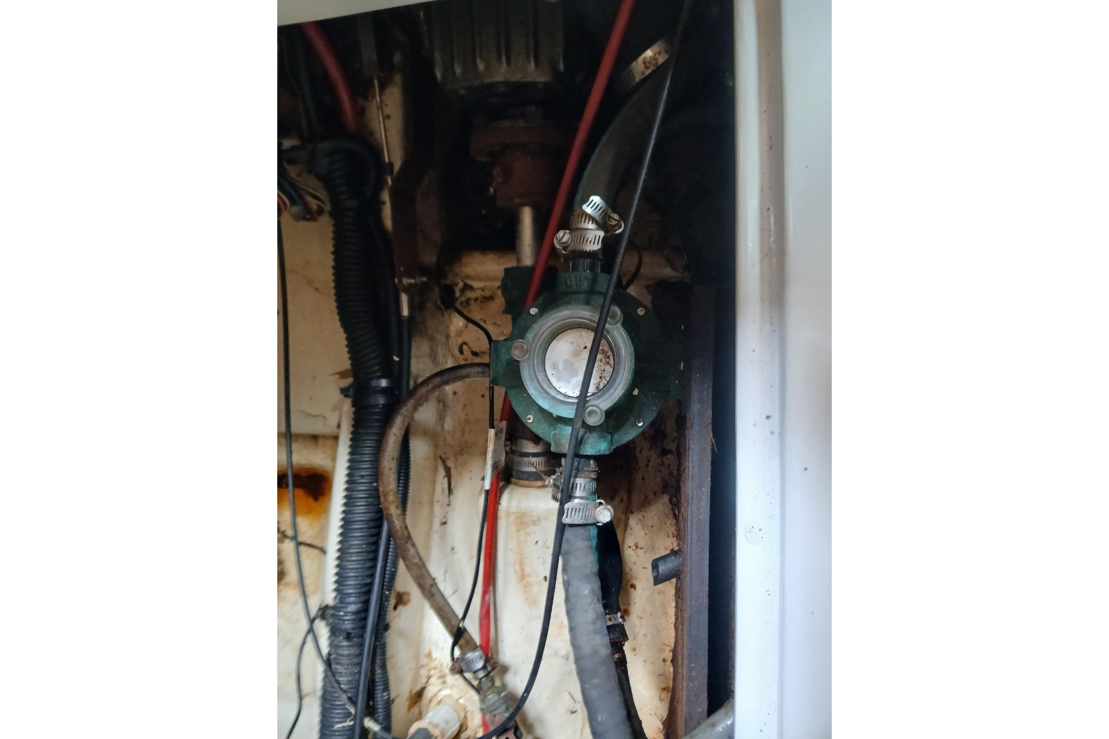 Engine compartment of a 1994 Hunter 30 sailboat, showing hoses and mechanical components.