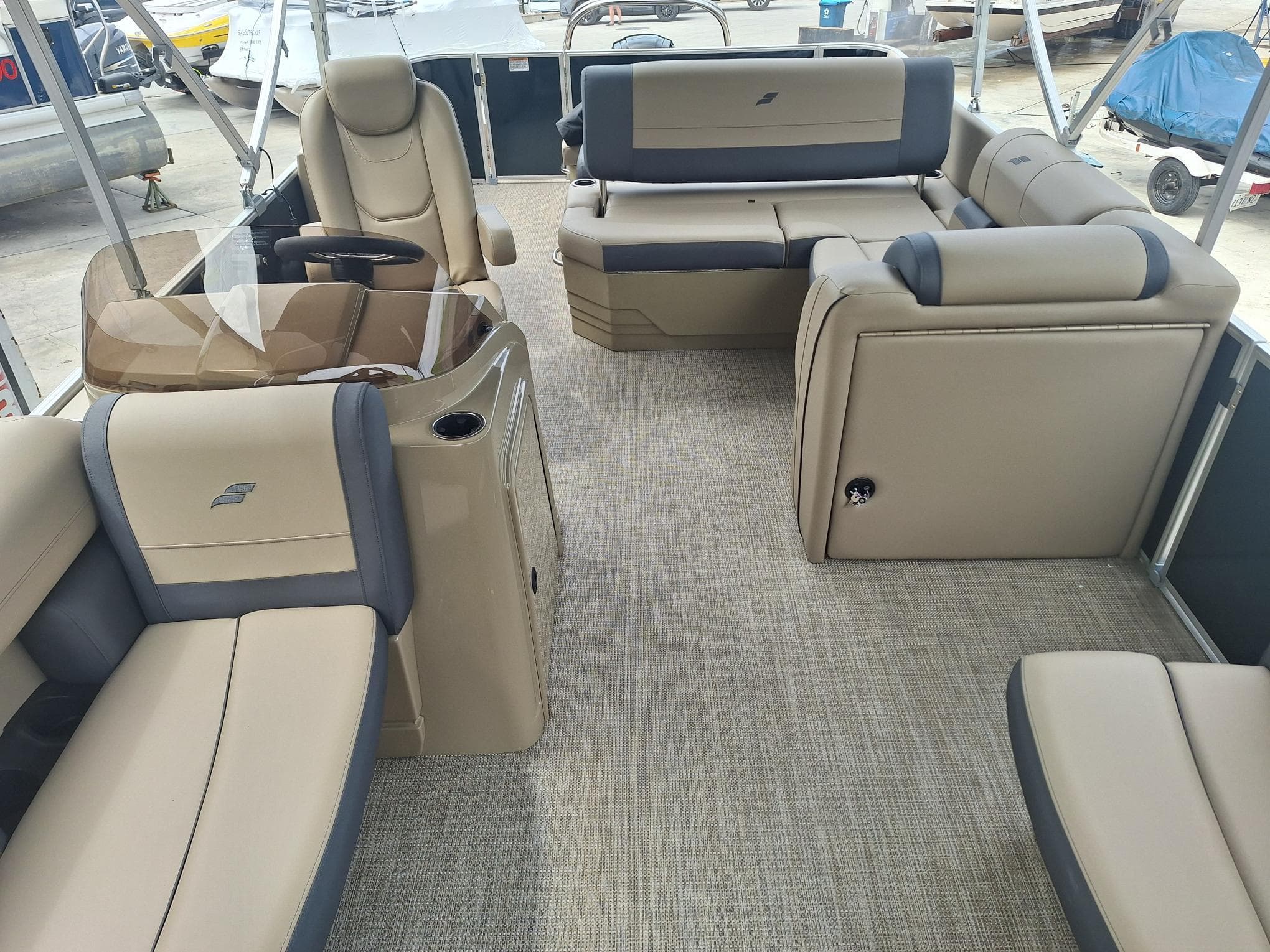 2024 Starcraft EX 22 Weekender boat interior with beige seating and carpeted flooring.