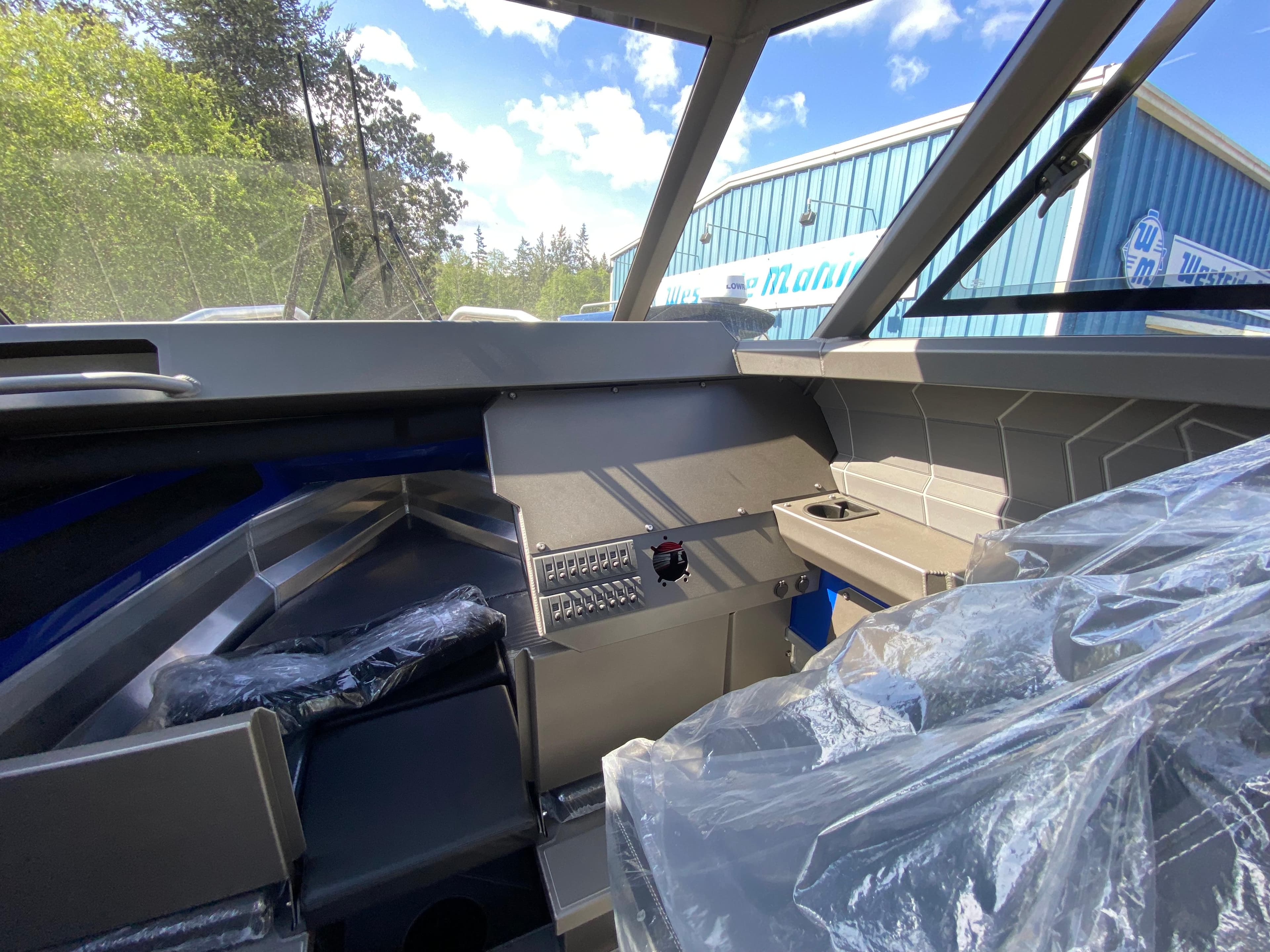 2025 Stabicraft 2350 Supercab interior with modern dashboard and seating, outdoors near a blue building.