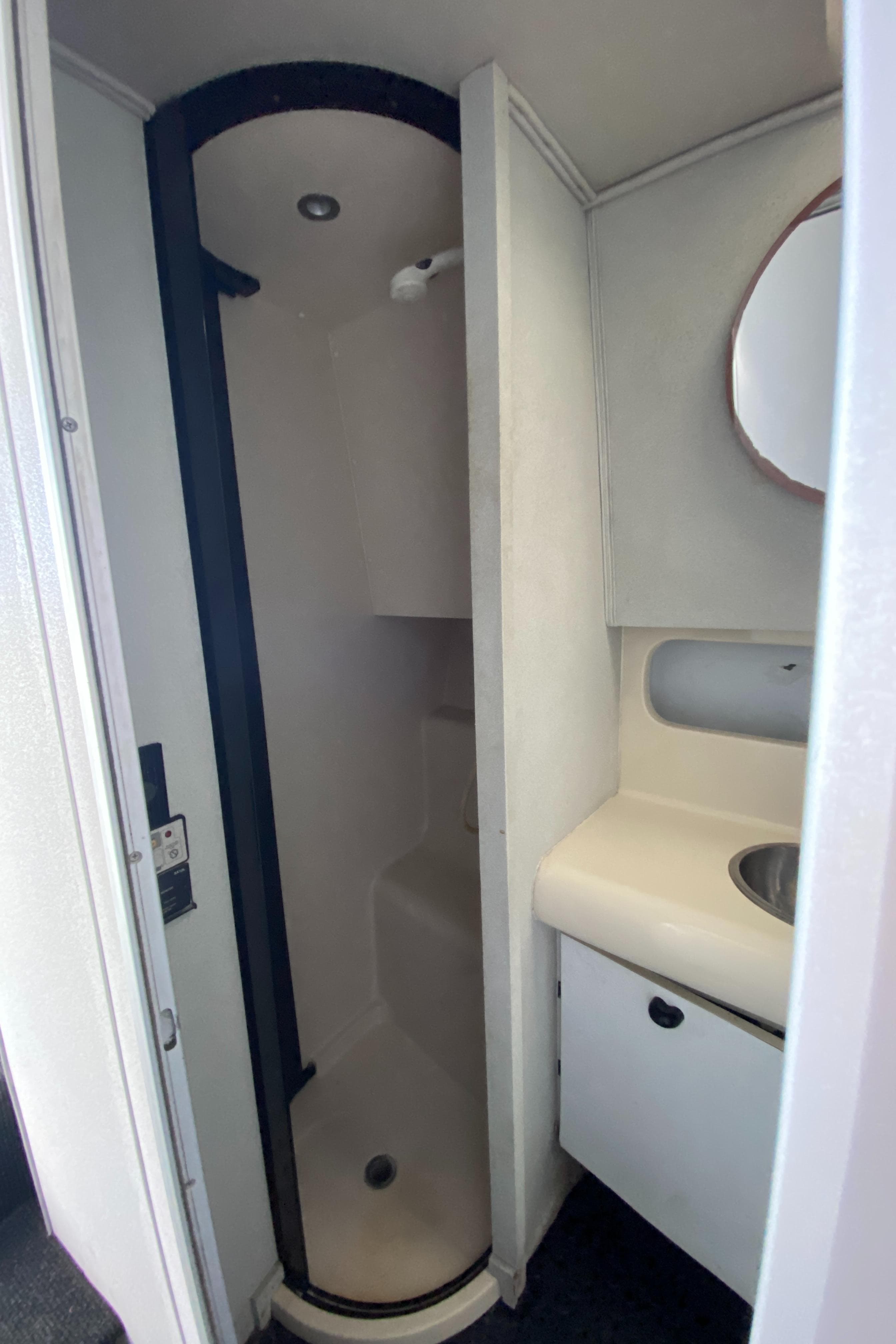1991 Mainship 41 Convertible bathroom with shower, sink, and mirror.