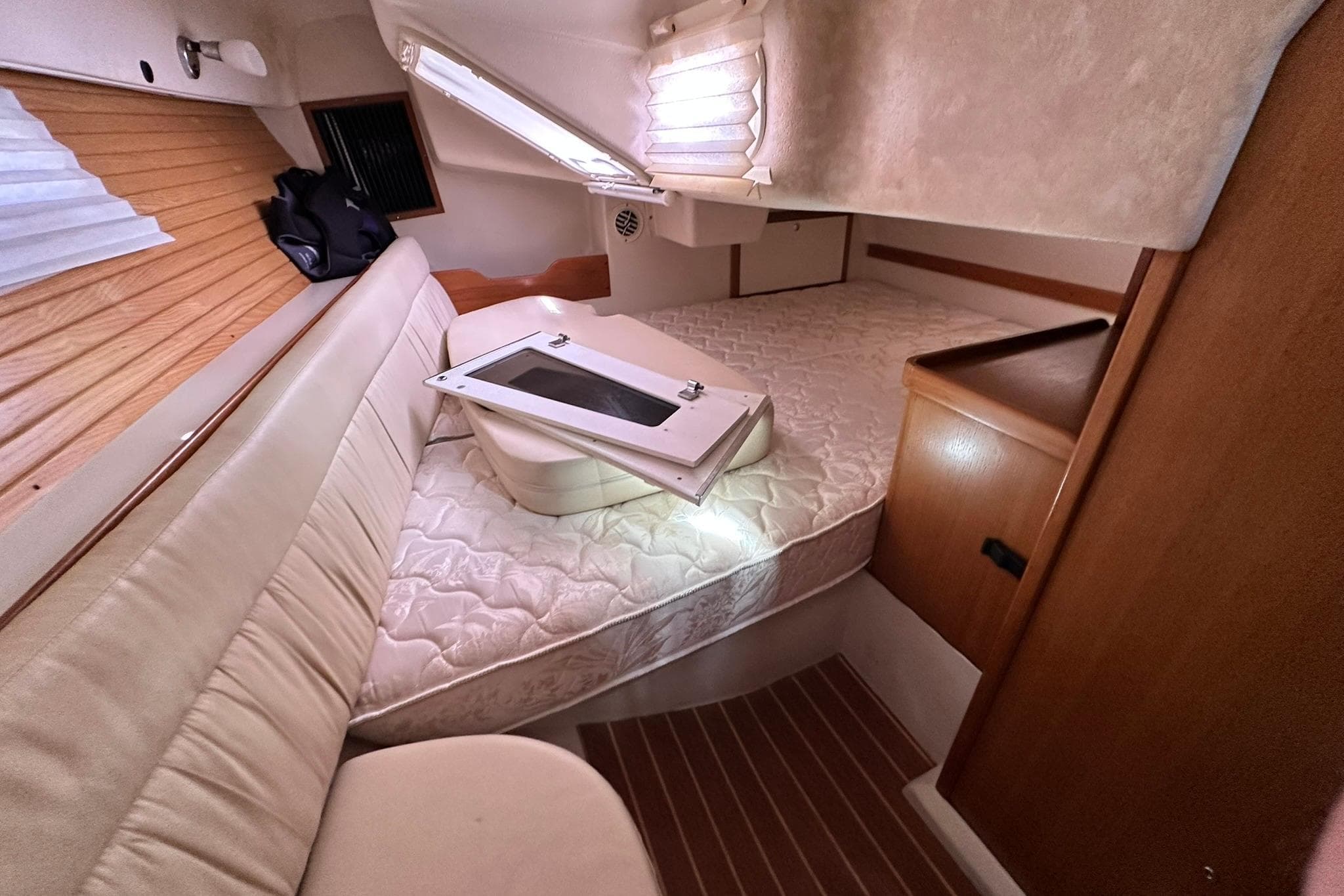 Interior cabin of a 2008 Catalina 320 sailboat with cozy seating and bedding.