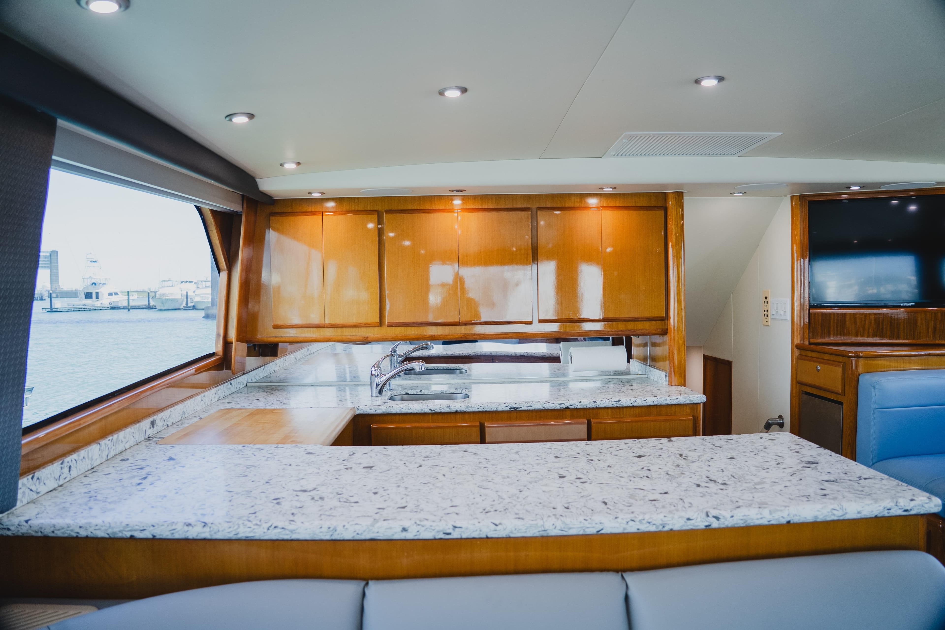 Luxurious interior of 1999 Viking 58 Convertible yacht with modern kitchen and granite countertops.