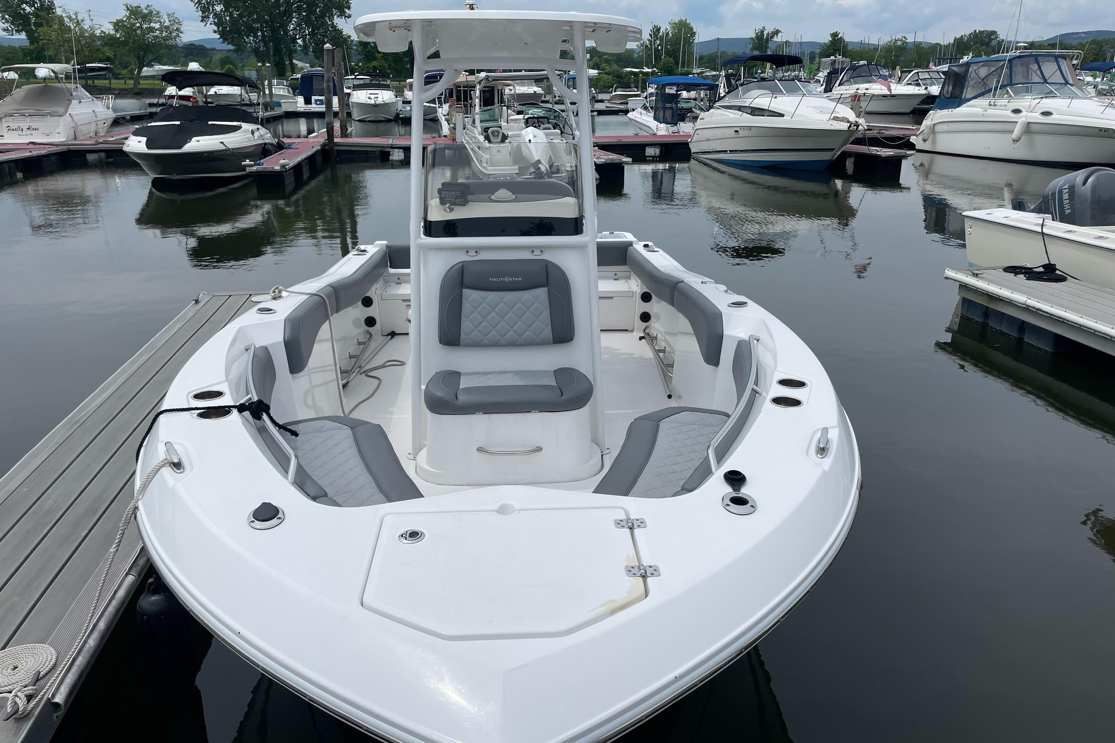 2024 NauticStar 222L Offshore boat docked at marina, featuring sleek design and spacious seating.