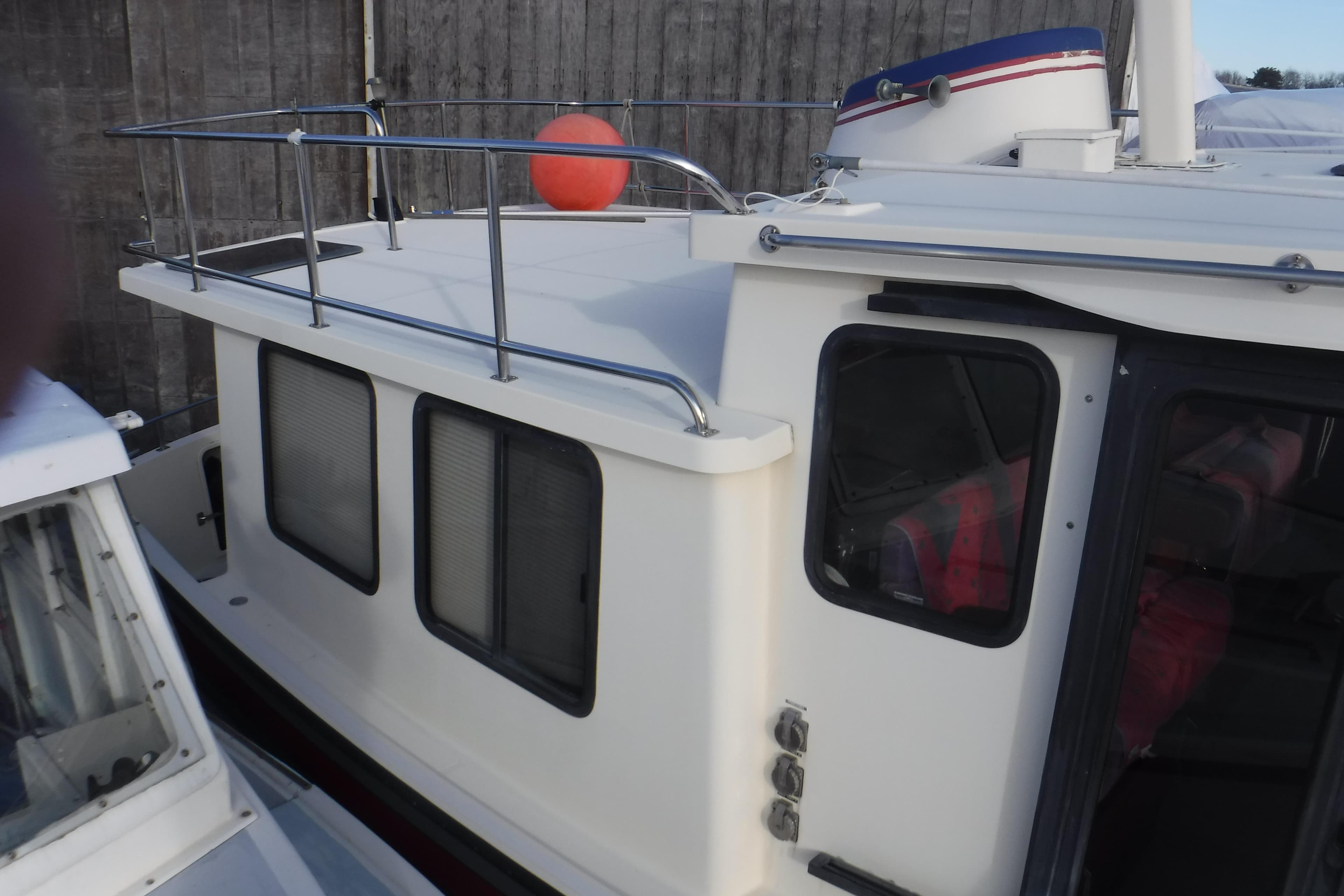 Nordic Tug 37, 2002 model, featuring a white cabin with metal railings and windows.
