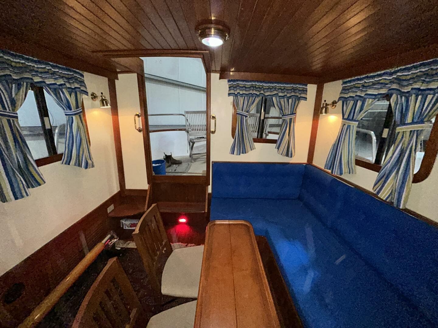 Interior of 1984 Lord Nelson 37 Victory Tug with blue seating and striped curtains.