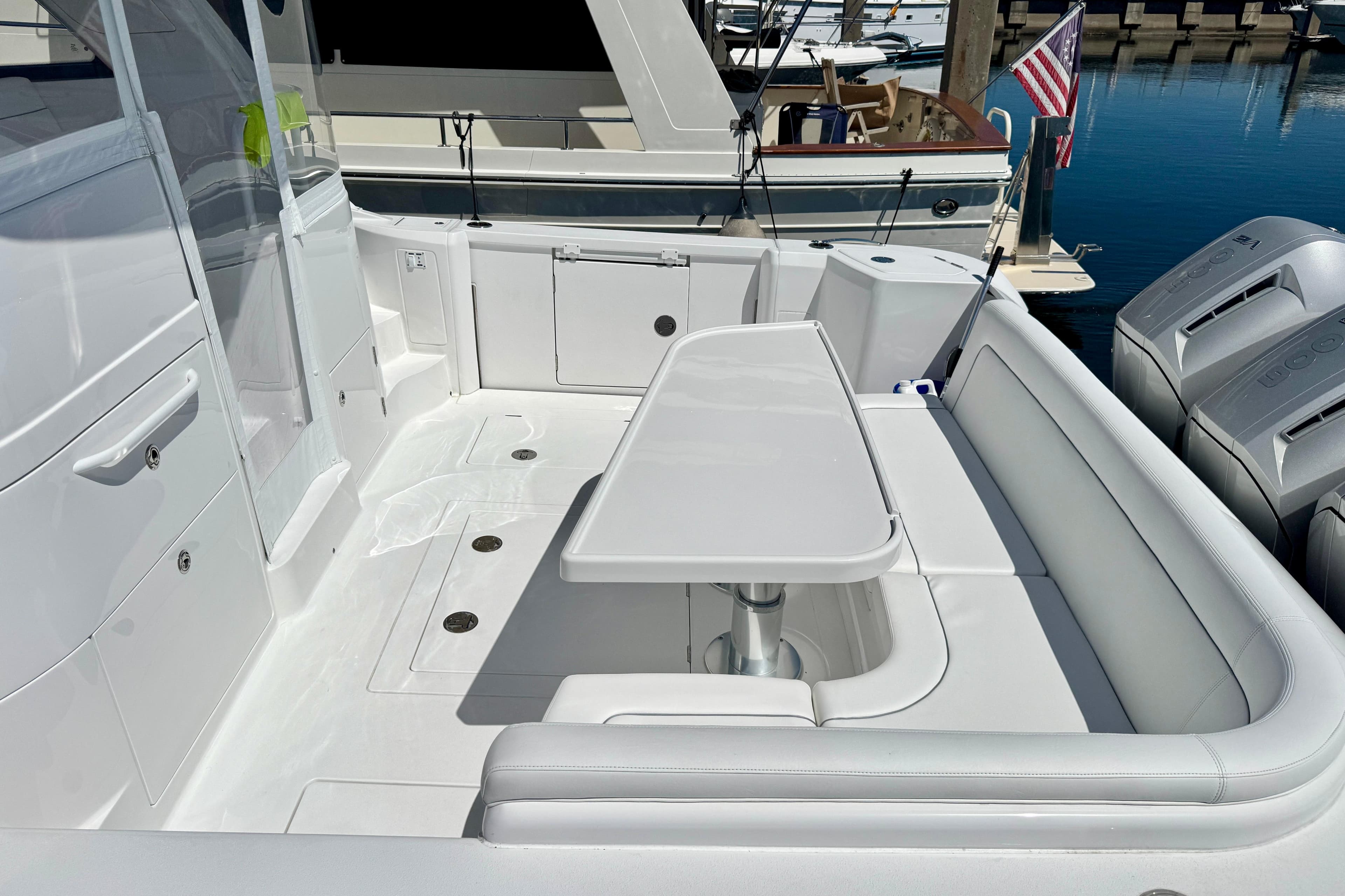 Luxury seating area on 2025 Intrepid 50 Evolution yacht, docked with outboard engines.
