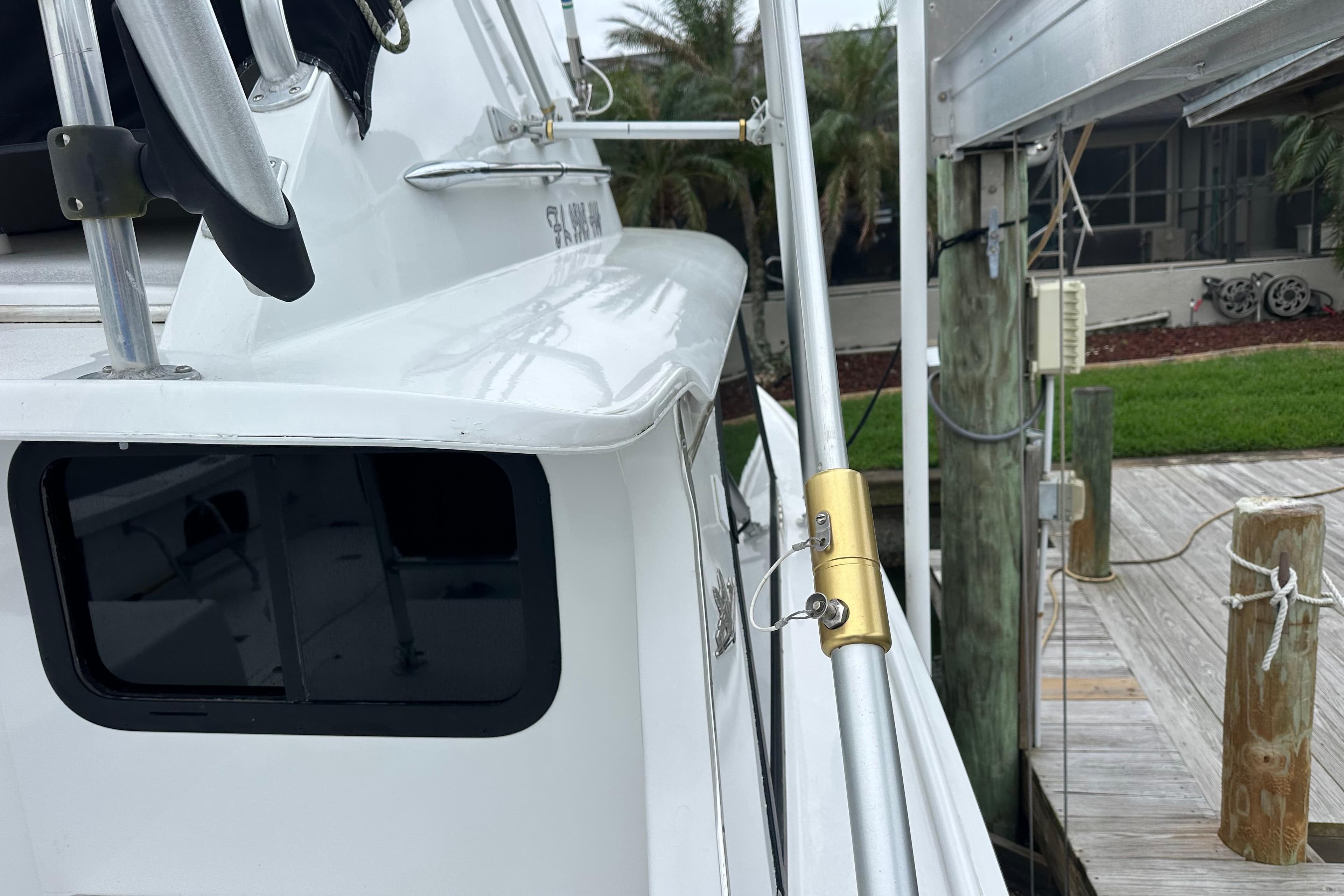 1975 Bertram 31 boat docked, showcasing sleek white exterior and fishing equipment.