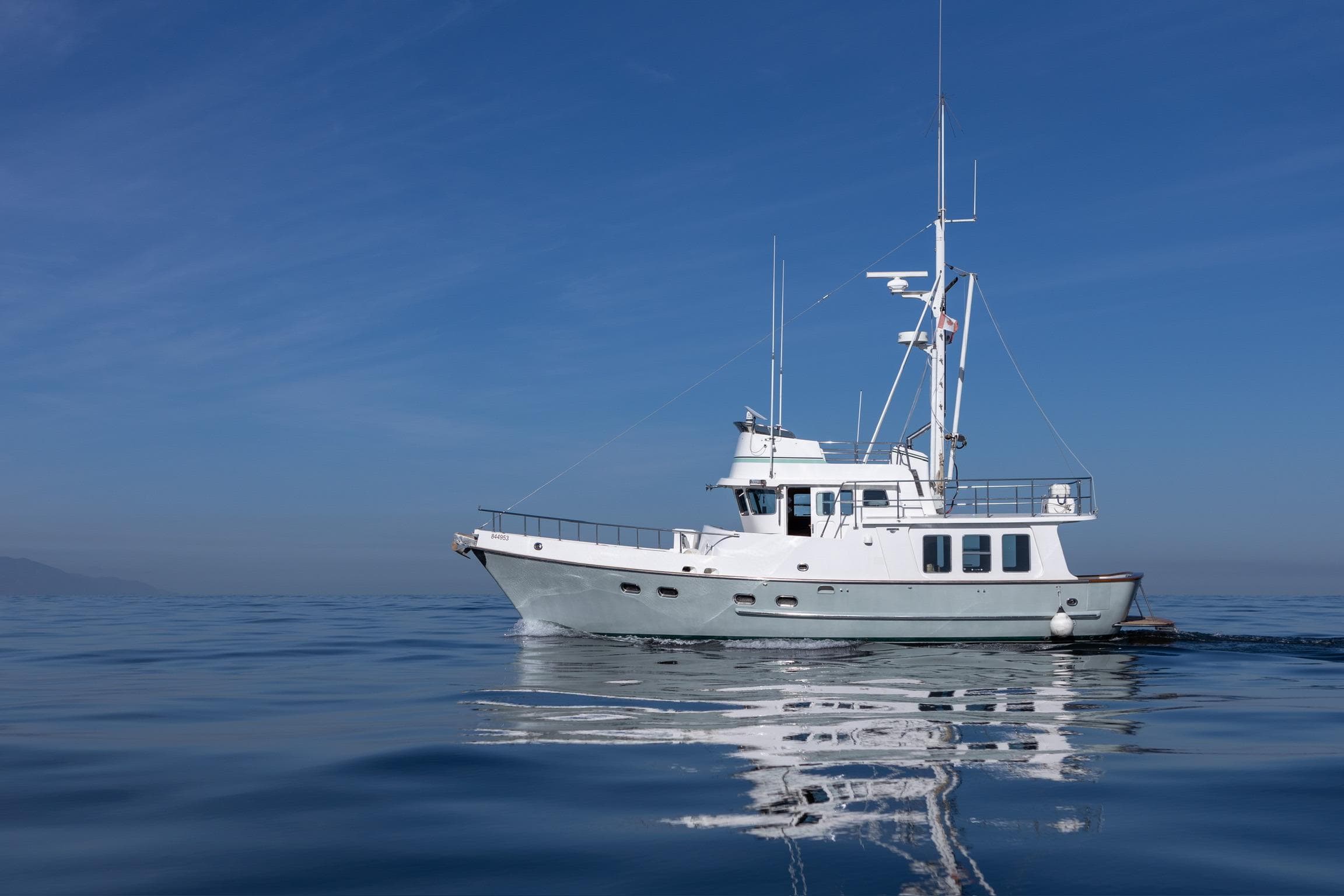 2003 Nordhavn 46 yacht cruising on calm blue ocean under clear sky.