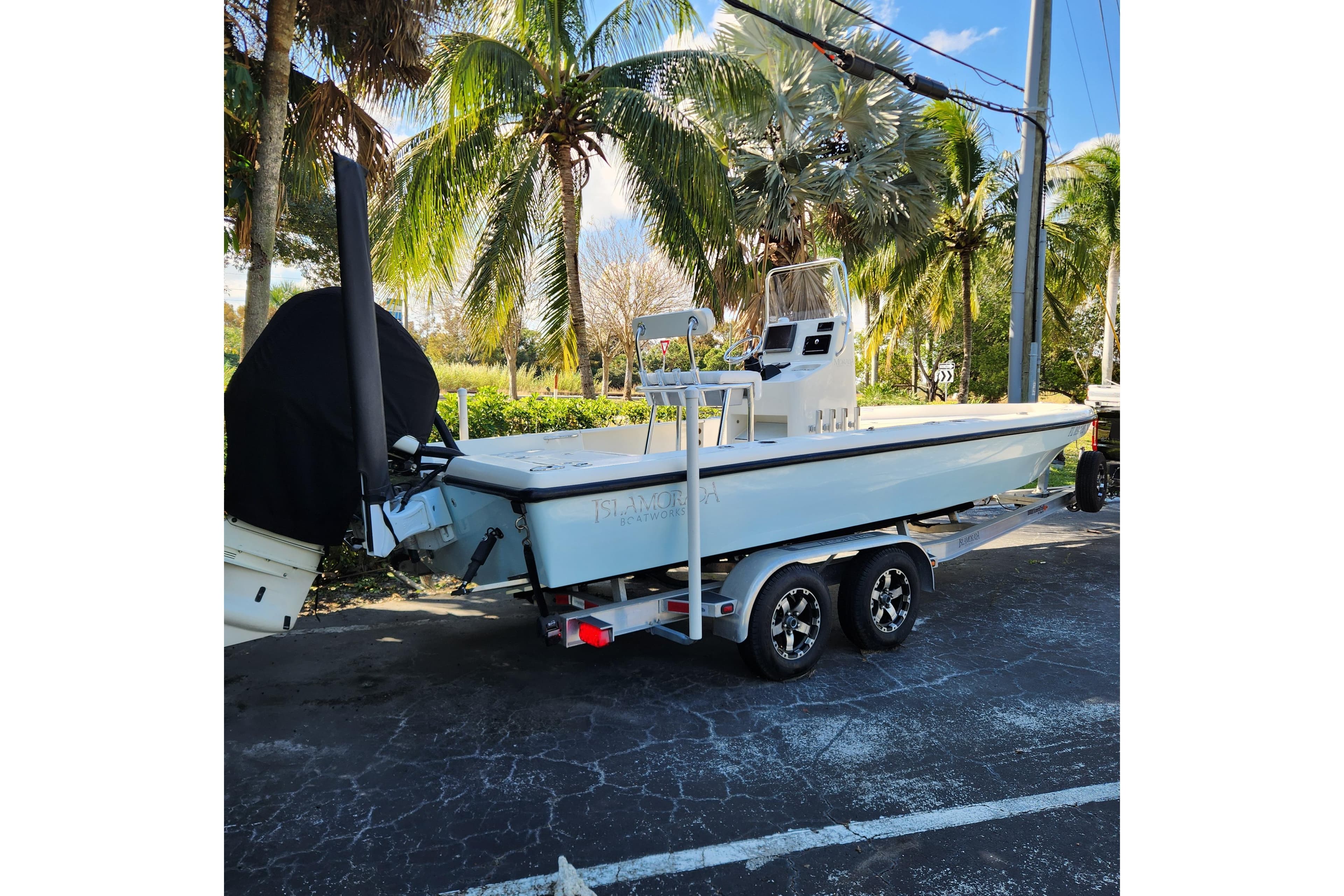 2014 Islamorada Boatworks Morada 24 on trailer, parked near palm trees.