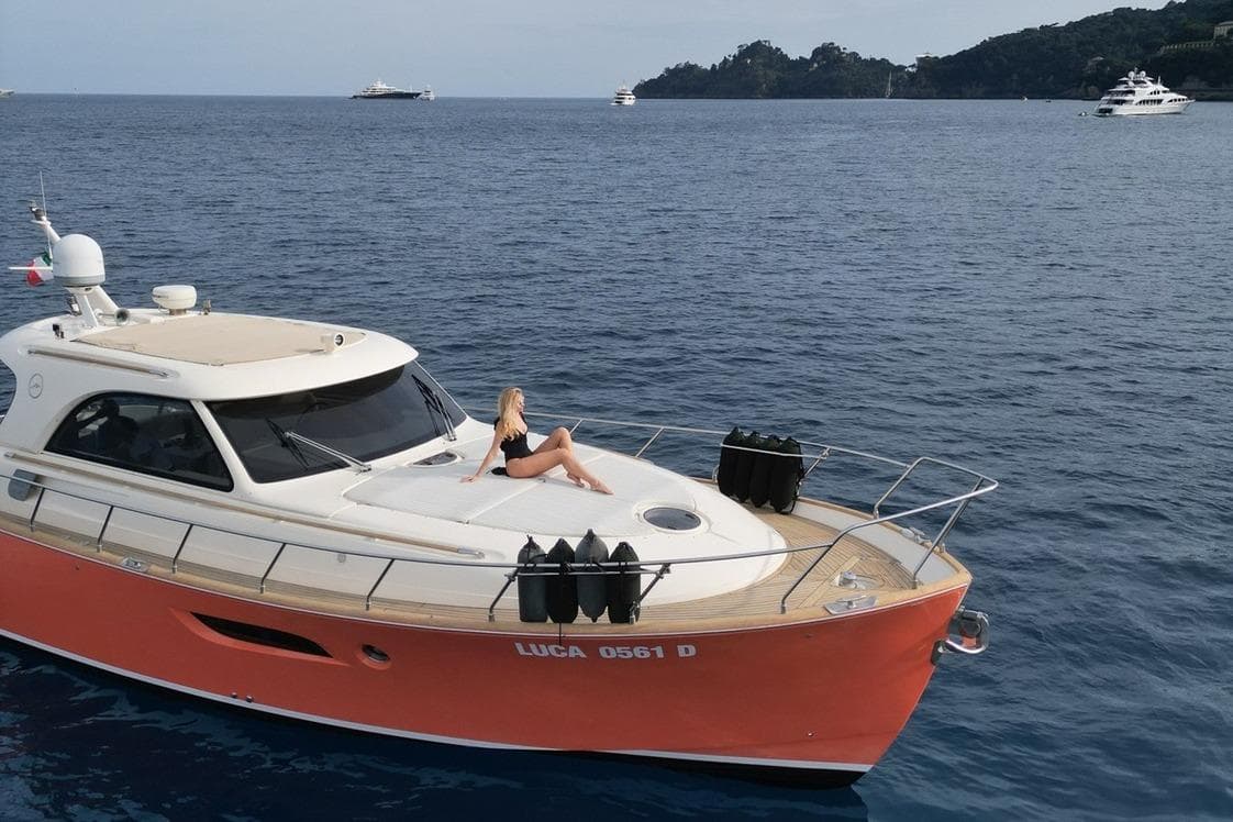 2005 MOCHI 44 Dolphin yacht with person relaxing on deck, cruising in open sea.