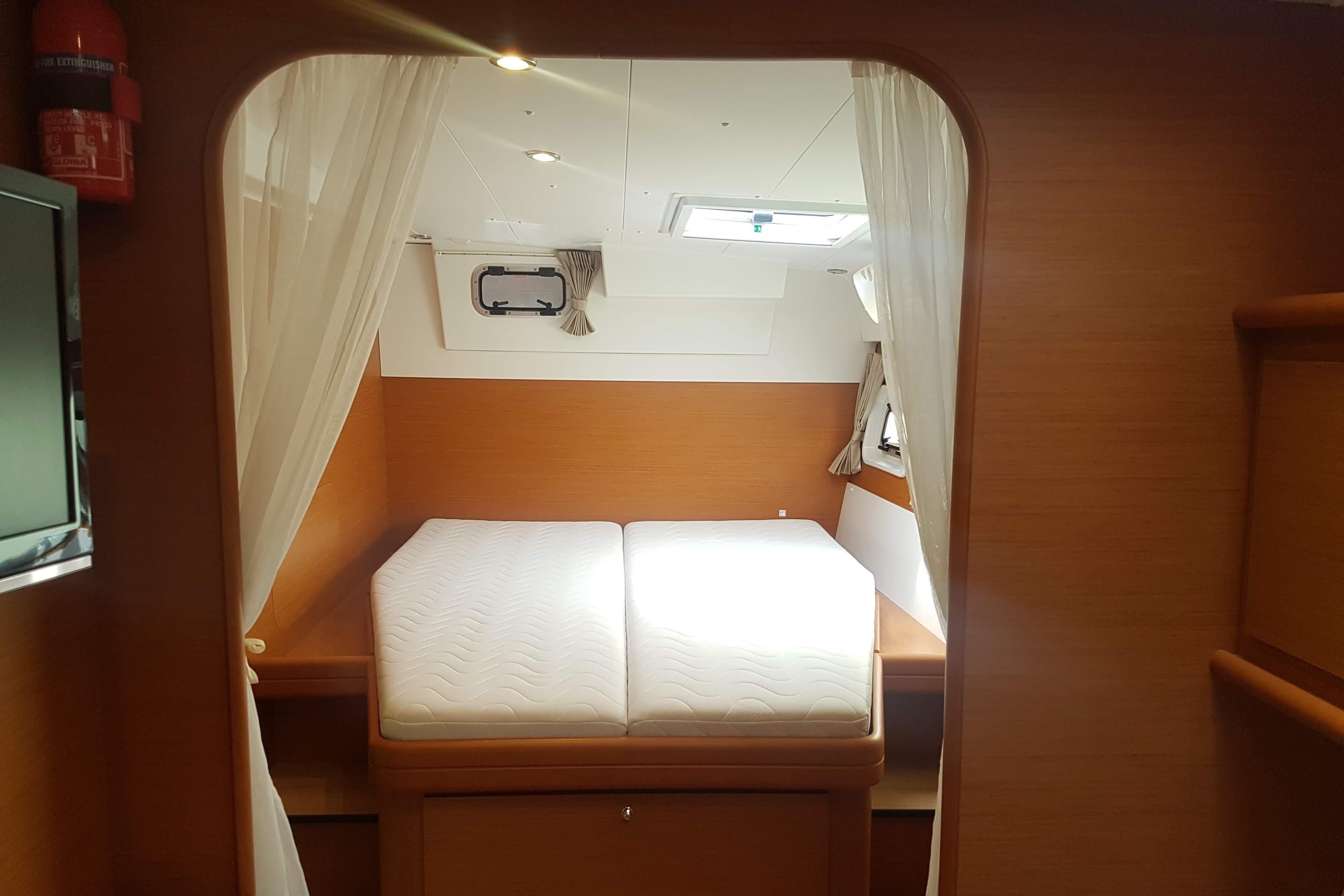 Cozy cabin interior of 2016 Lagoon 421 catamaran with double bed and curtains.