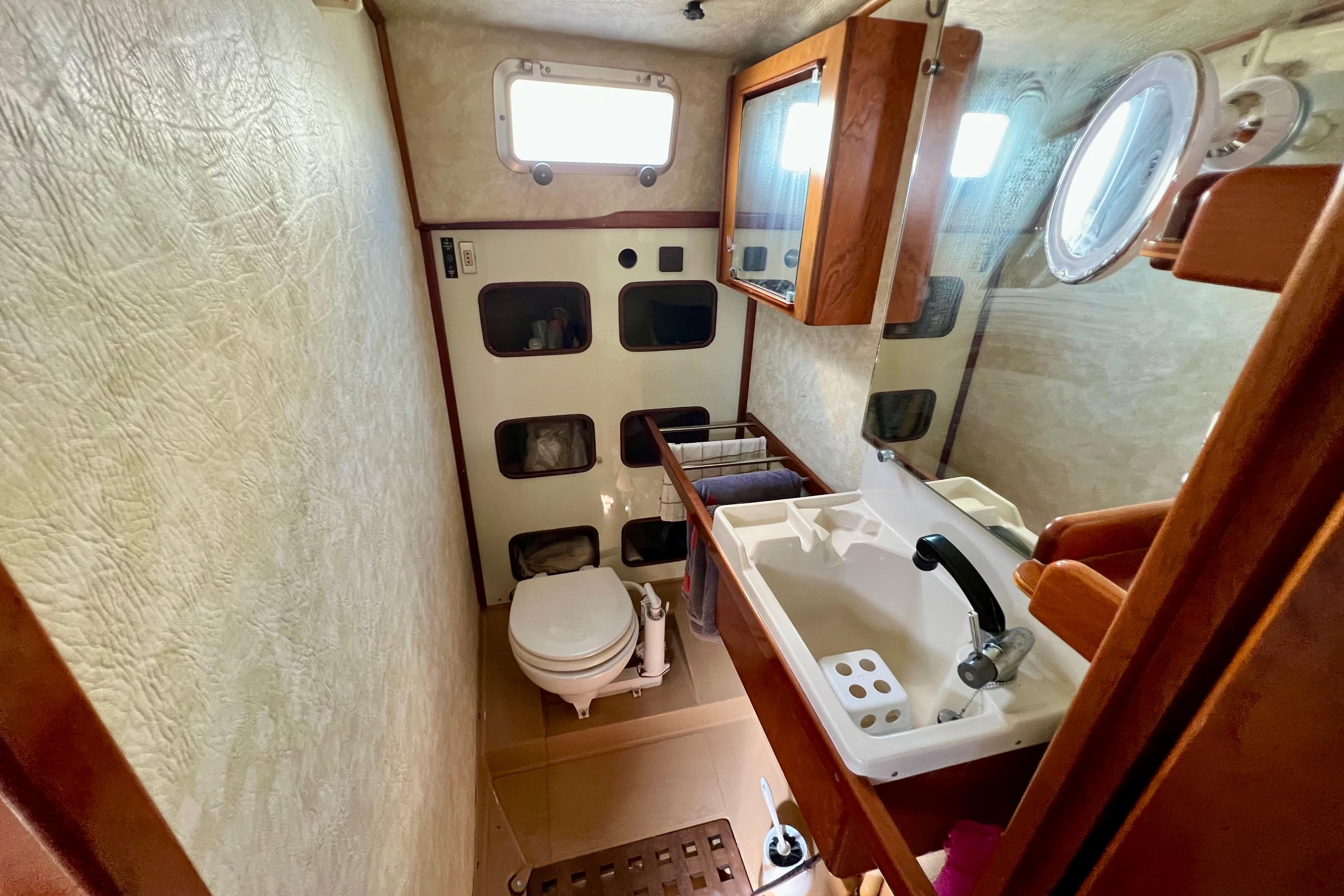 Bathroom interior of 1995 Amel Santorin 46 yacht with sink, toilet, and storage.