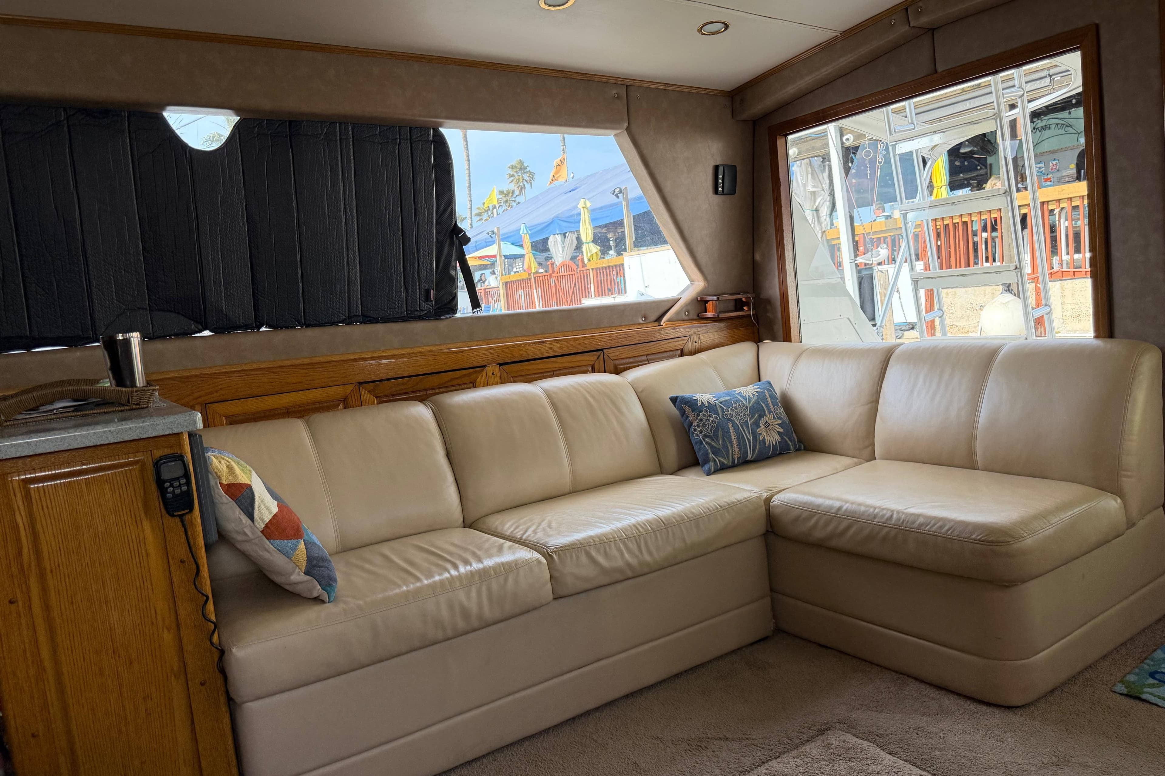 Interior of 1984 Bertram 42 Convertible yacht with beige leather sofa and decorative pillows.