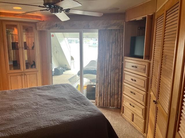 Interior of 2001 Stardust Cruisers houseboat bedroom with wooden cabinetry and sliding glass doors.