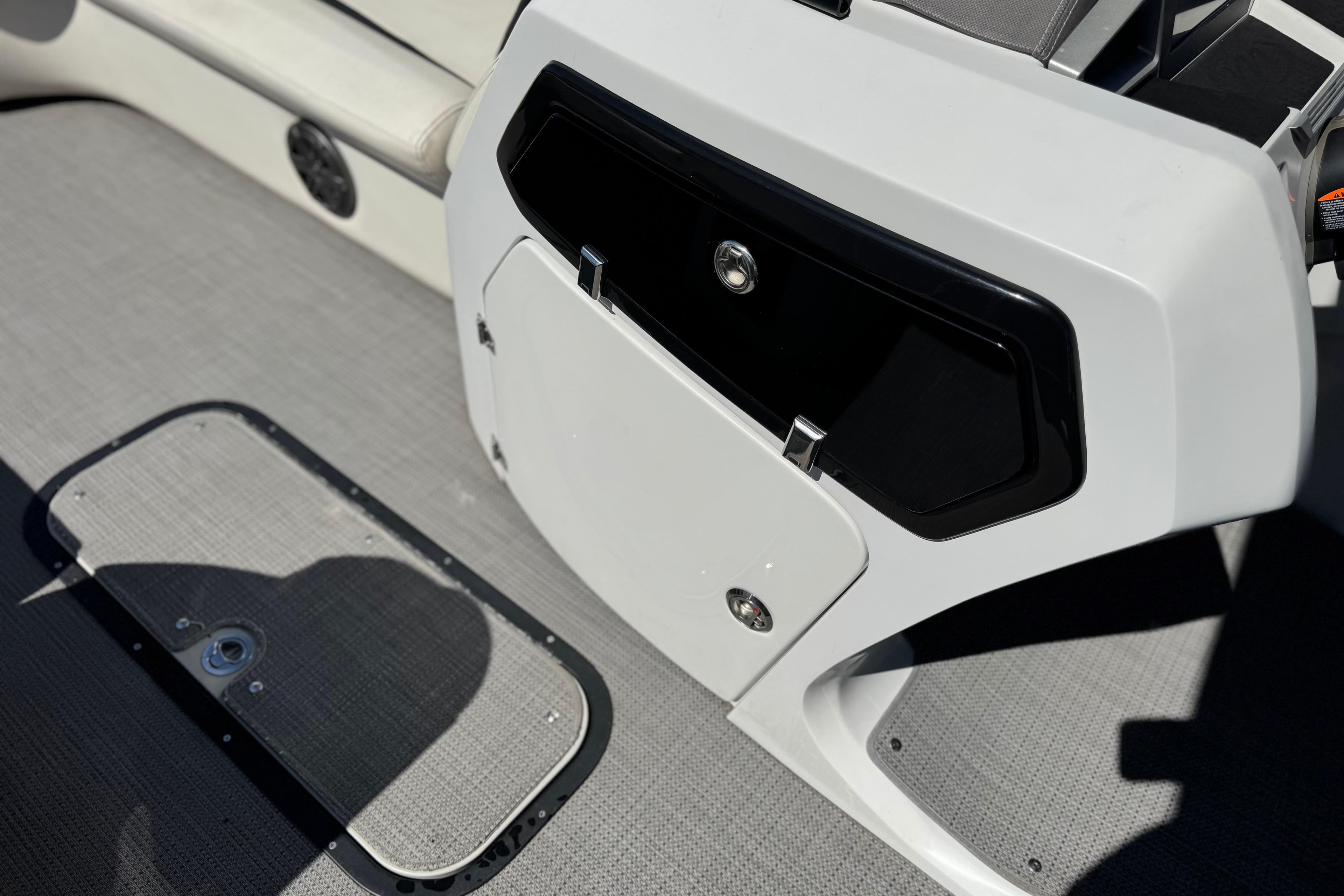 2021 Manitou 25 LX SHP boat interior with storage compartment and speaker.