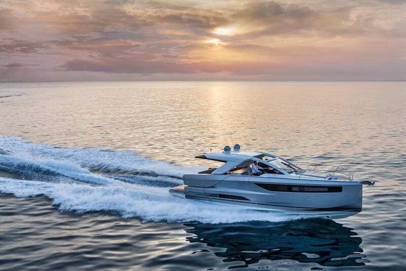 2025 Jeanneau DB|43 Inboard yacht cruising at sunset on calm waters.